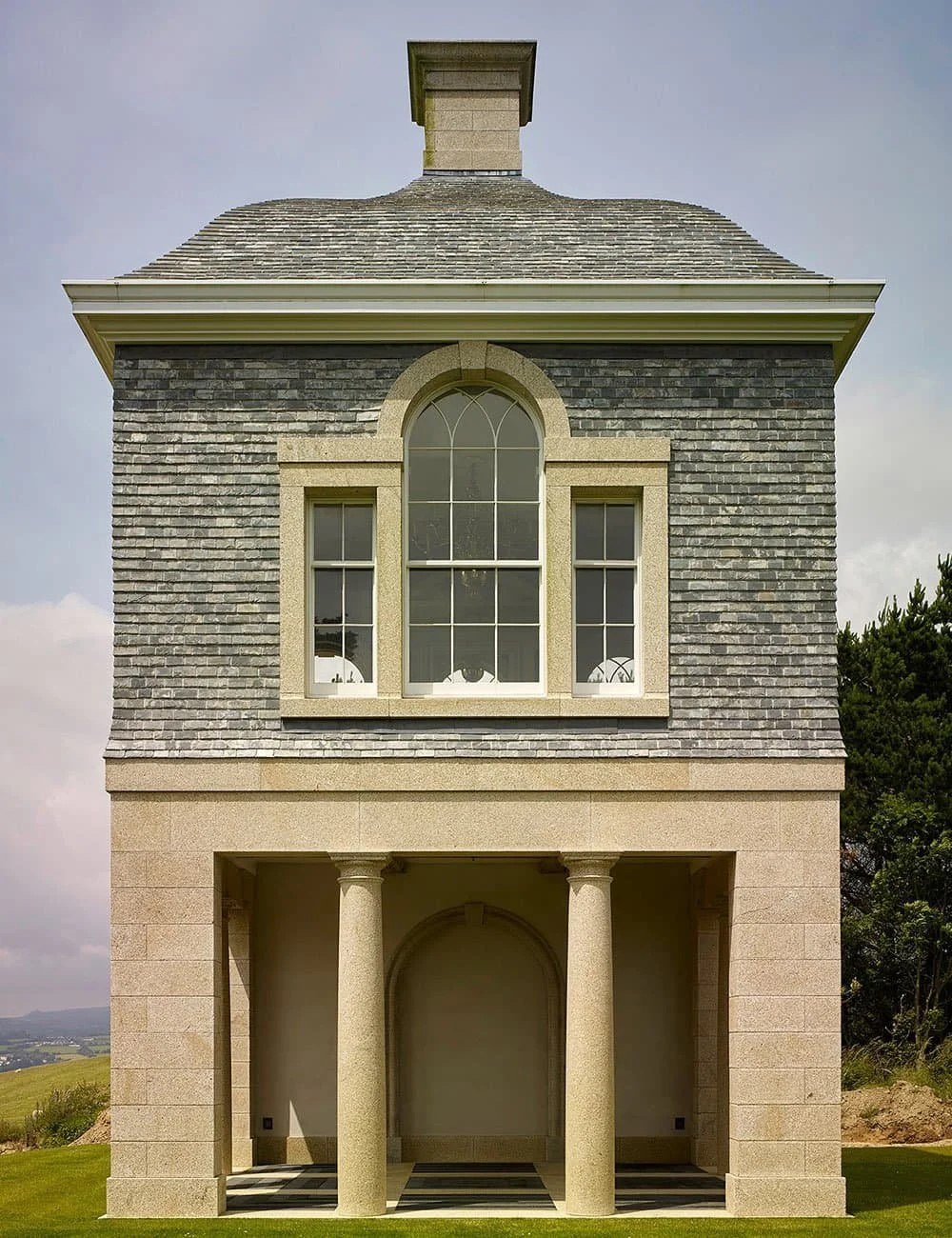 Front elevation of a classical garden pavilion in Cornwall with stone columns and arched window detailing.