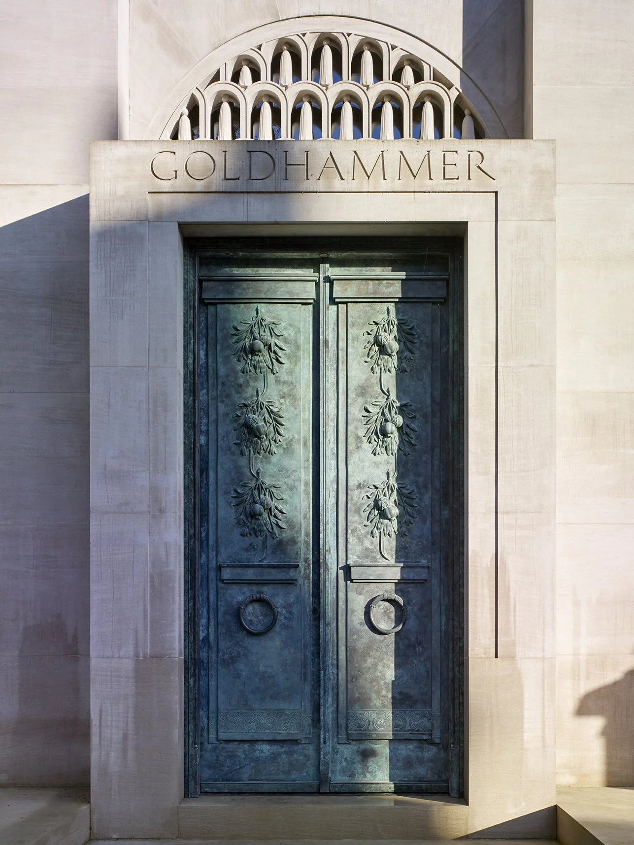 Close view of the mausoleum entrance with bronze doors, carved stonework and classical architectural proportions.