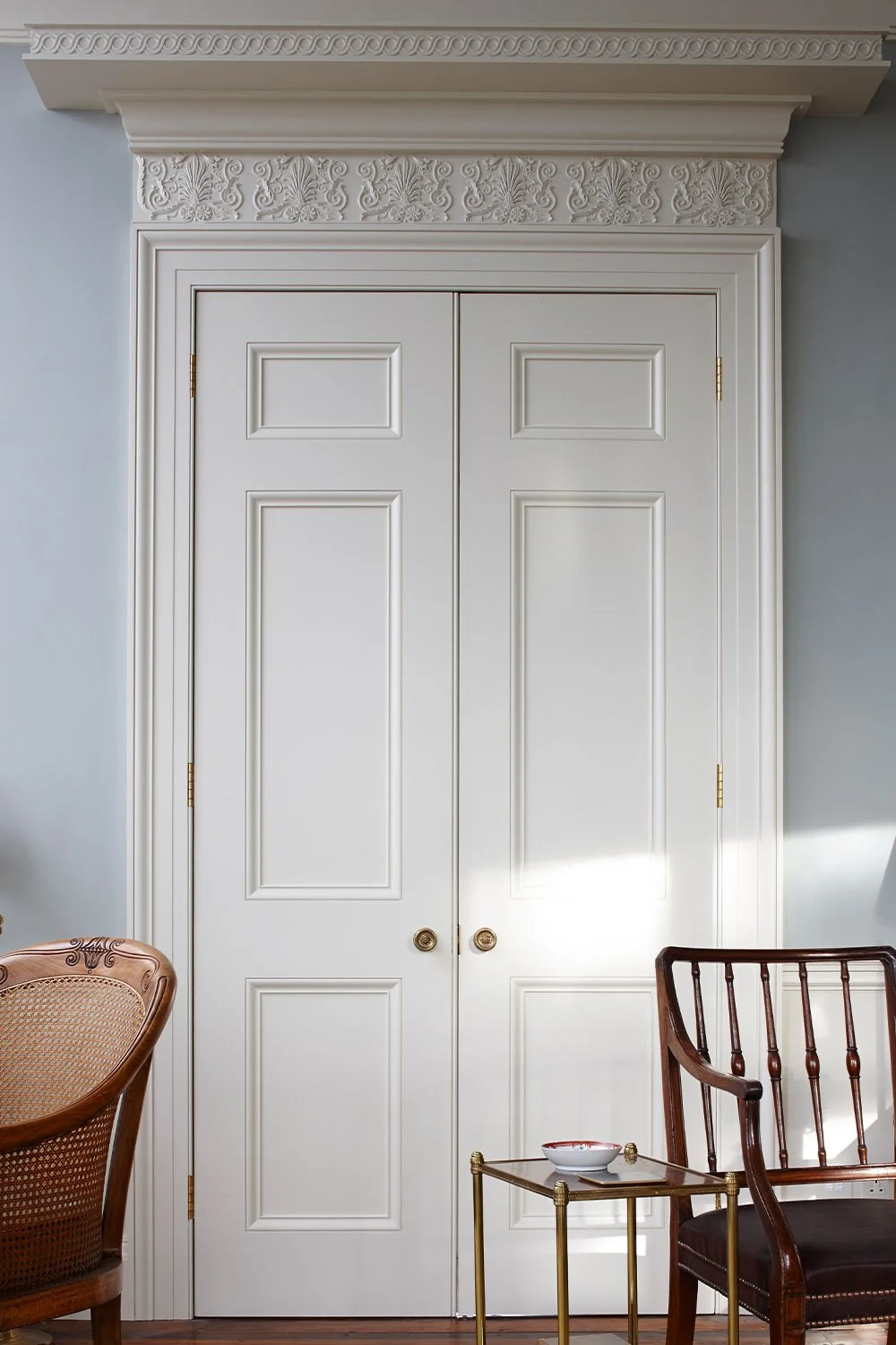 Architectural detail of a classically detailed doorcase with decorative cornice and traditional joinery in a historic London apartment.