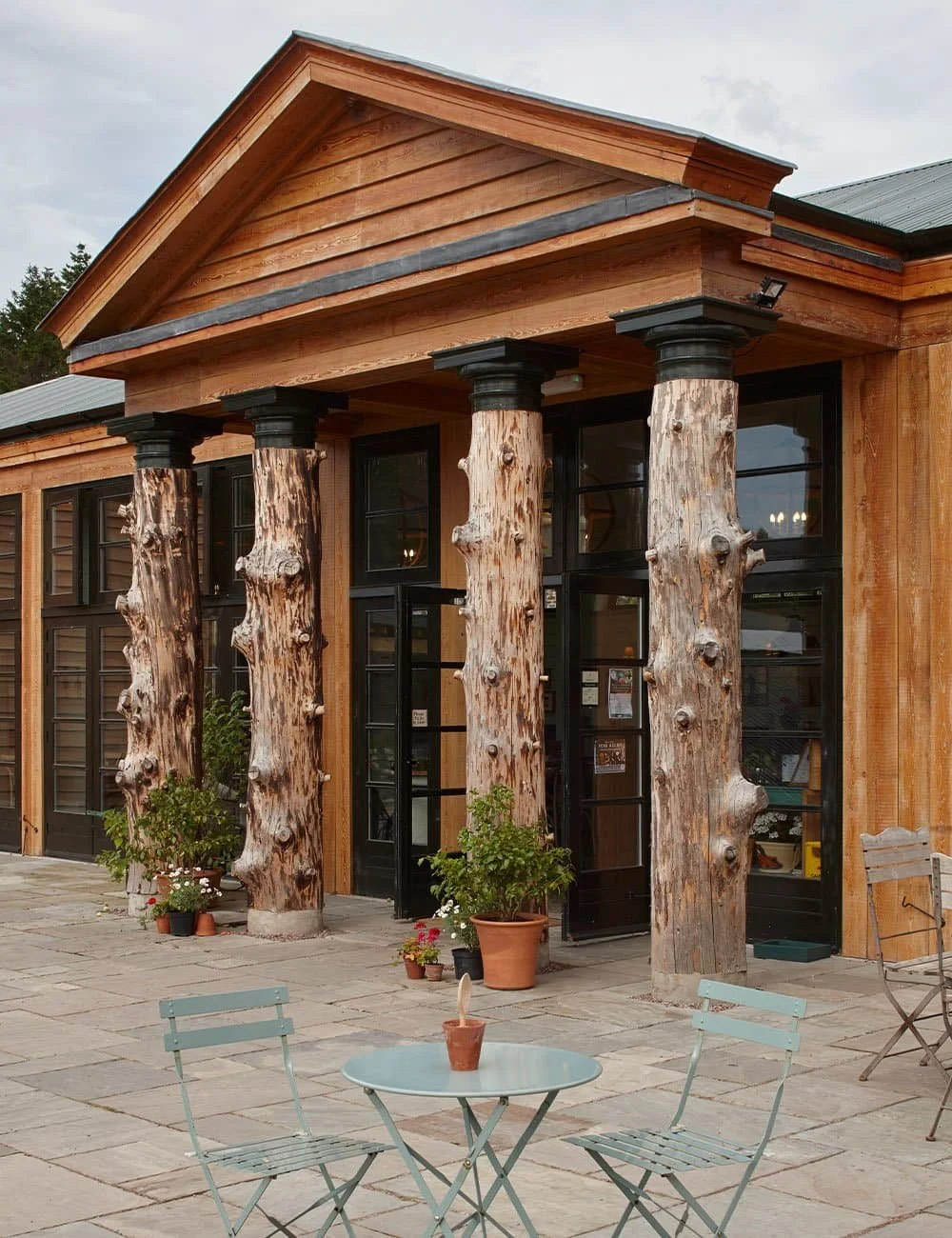 Classical entrance portico at Gordon Castle Walled Garden featuring distinctive tree-trunk timber columns