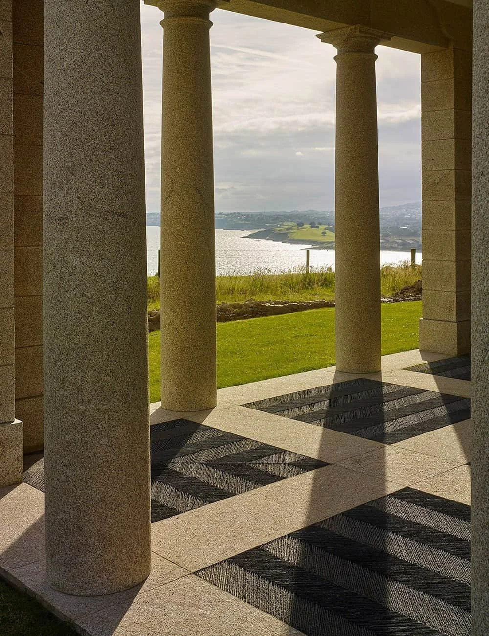 Stone-columned loggia within a Cornwall garden pavilion overlooking the surrounding landscape and coast.