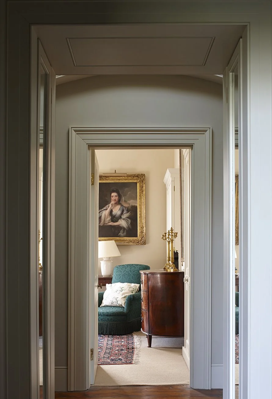 View through a sequence of principal rooms within a historic London apartment, showcasing classical proportions, decorative mouldings and period furnishings.