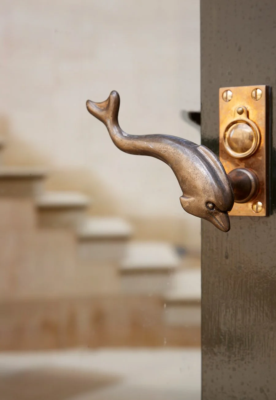 Bespoke bronze dolphin door handle detail within the Gloucestershire bath house.
