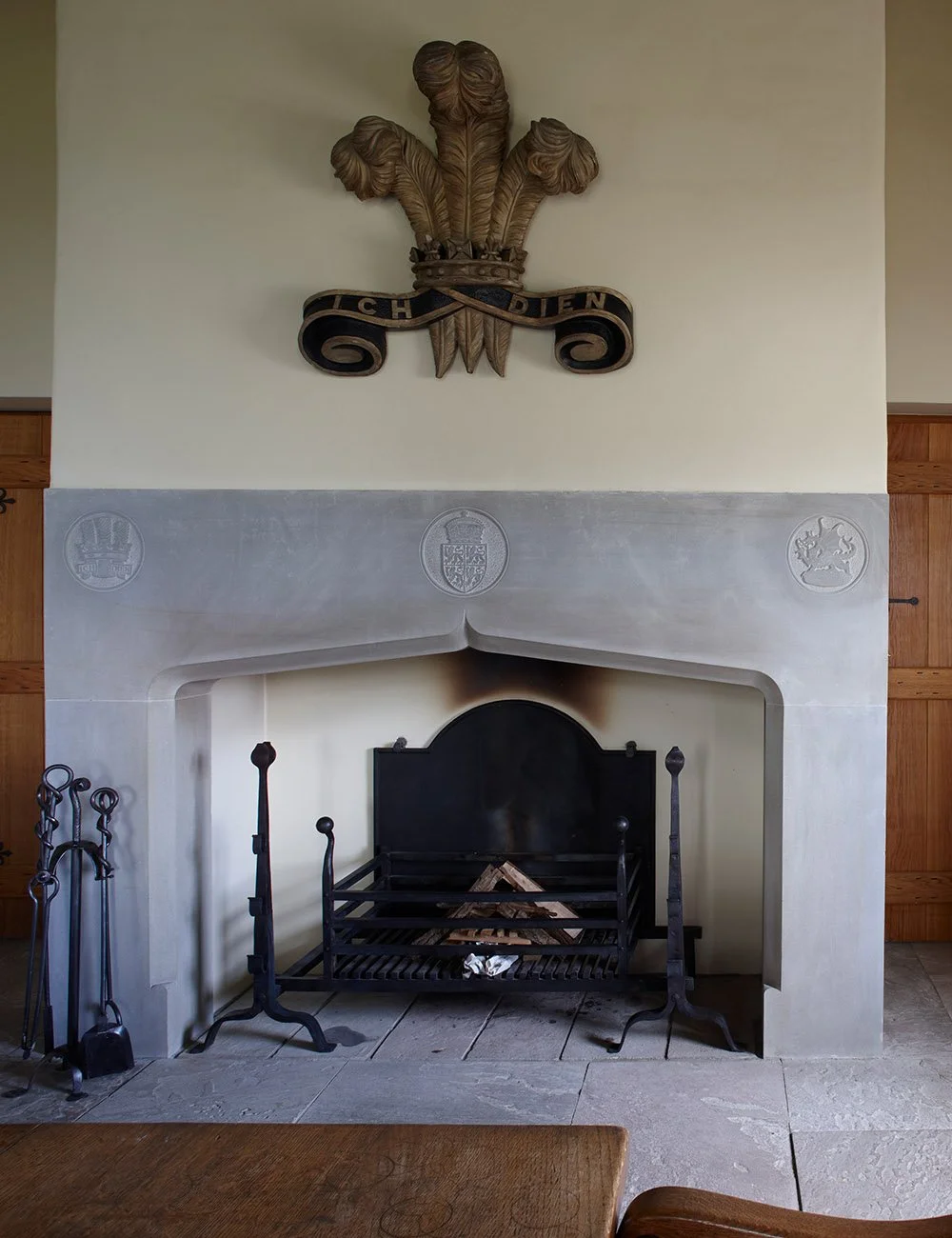 Handcrafted stone fireplace with carved Welsh emblem in the restored country house at Llwynwermod.