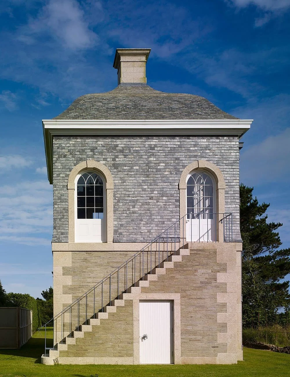 Classical garden pavilion in Cornwall with external stone staircase, arched openings and traditional detailing.