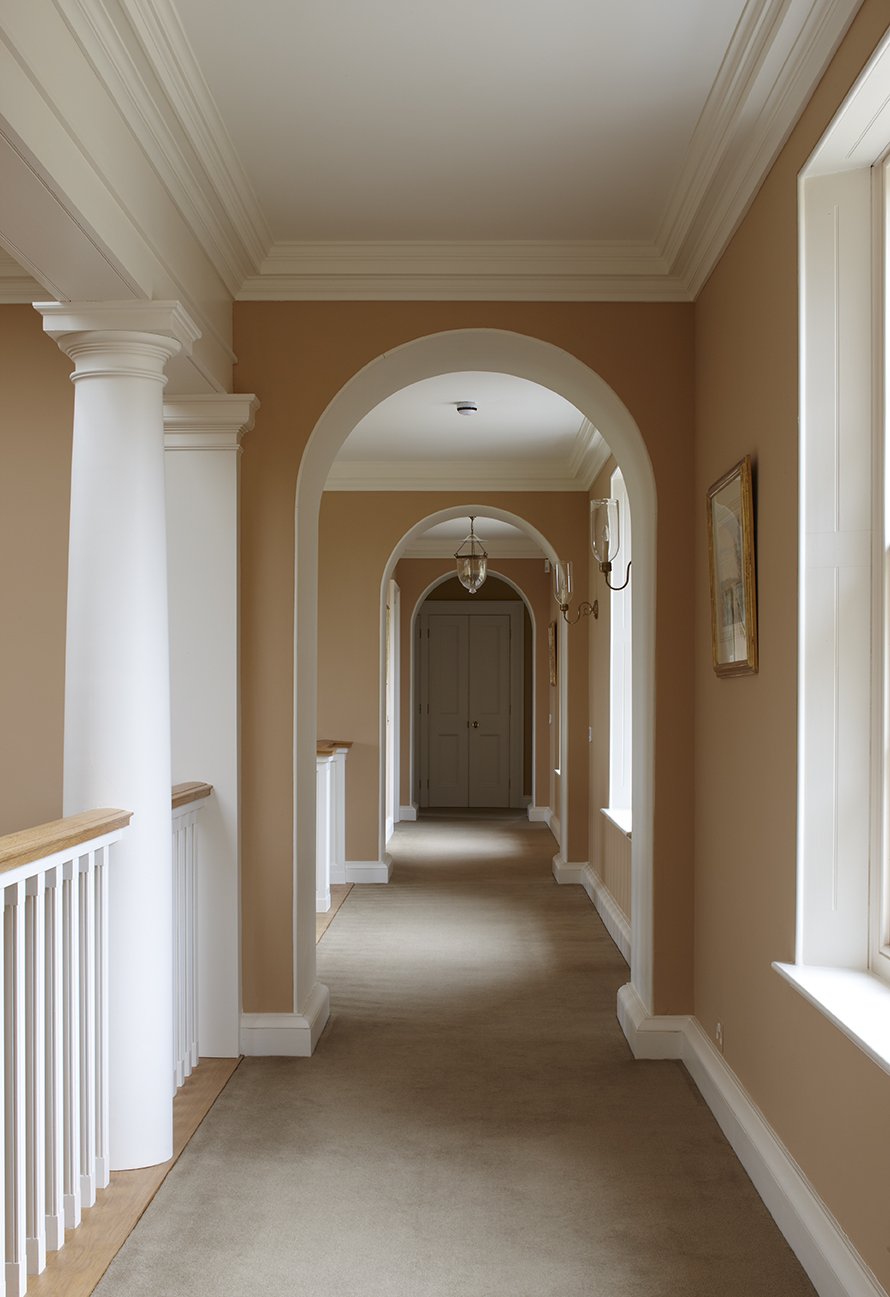 Arched interior corridor in classical Gloucestershire country house by Craig Hamilton Architects
