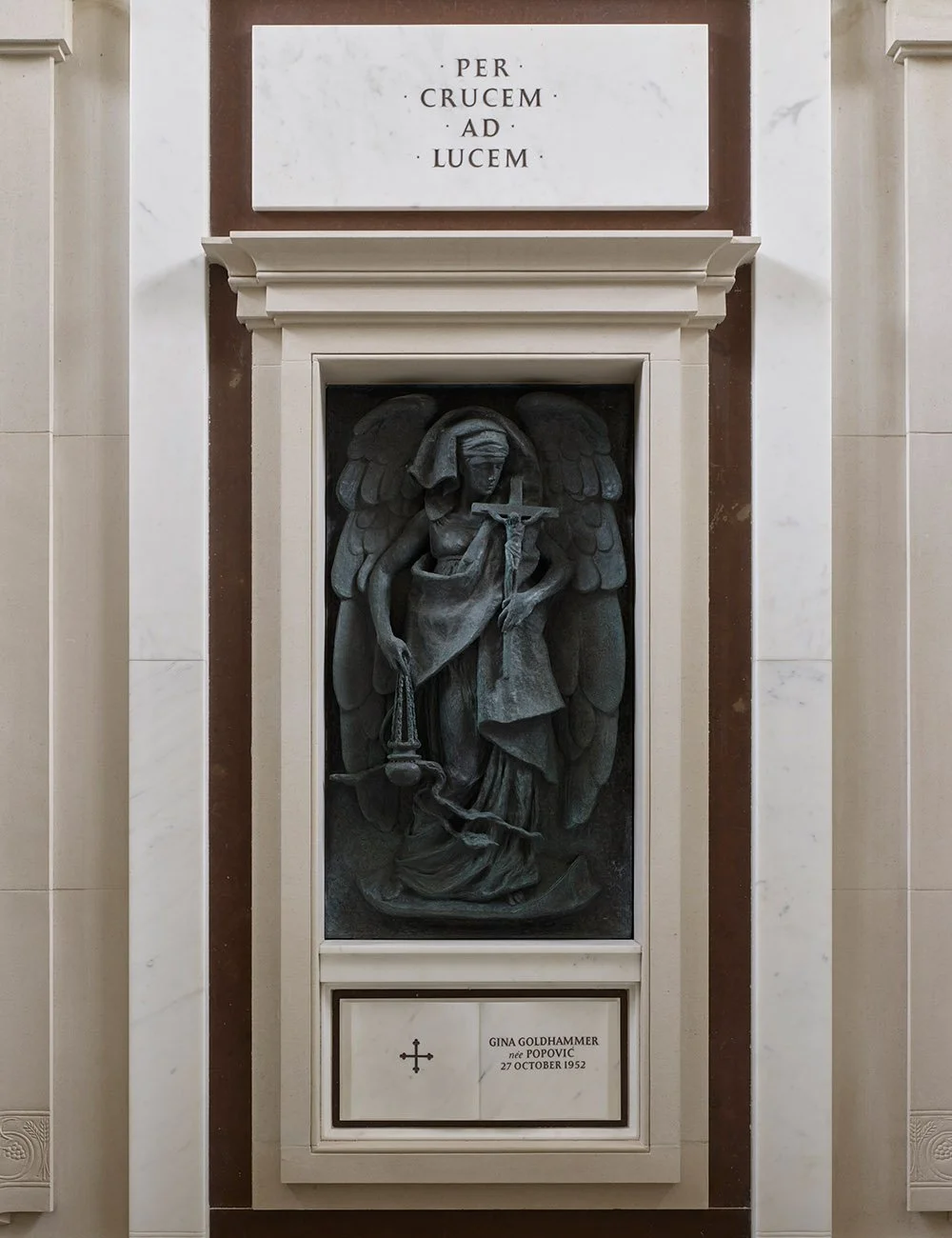 Bronze memorial figure displayed within a stone niche, reflecting the craftsmanship and symbolism of the mausoleum interior.