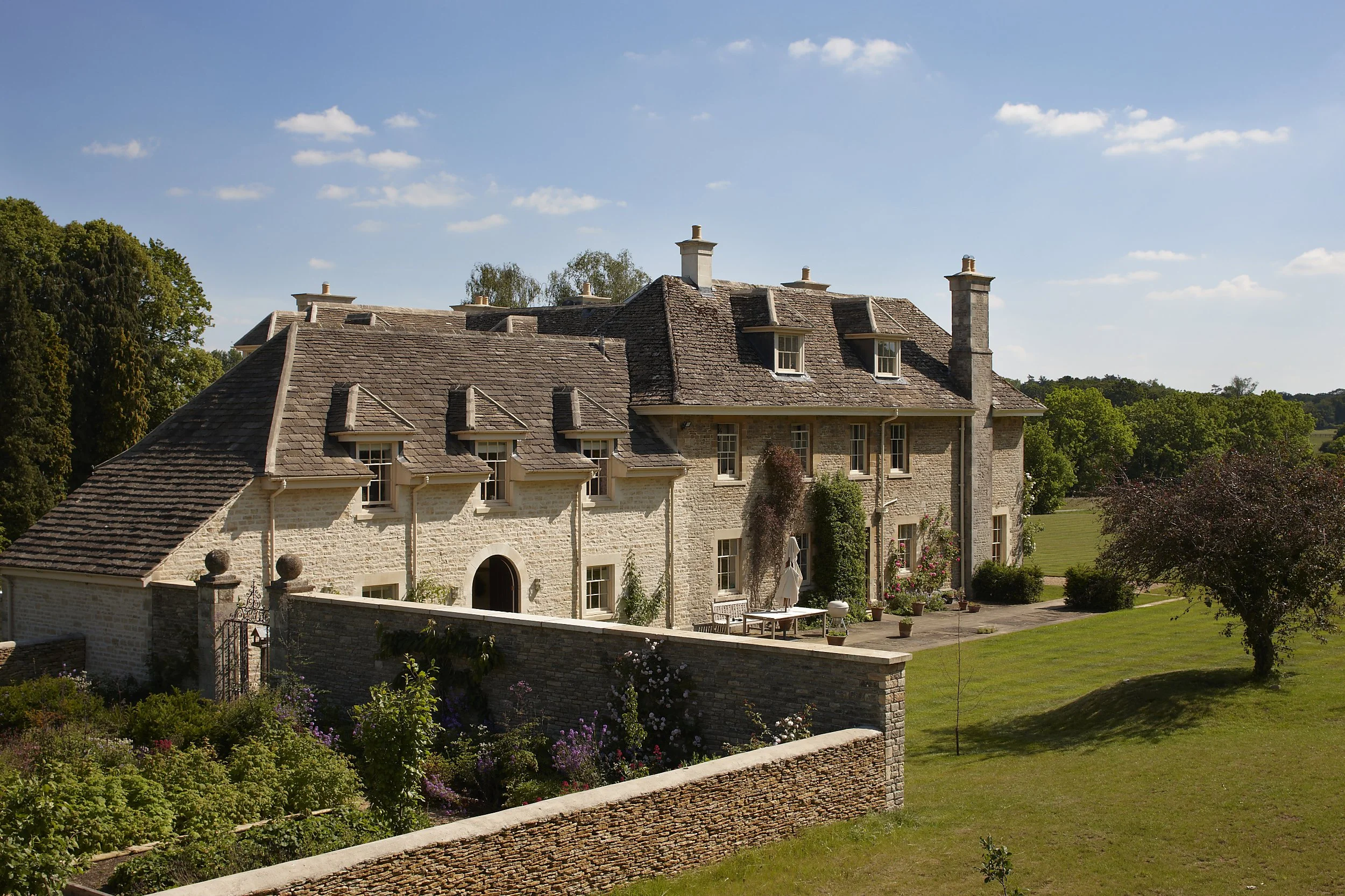 Traditional Cotswolds country house with limestone walls, formal garden terrace and classical architectural detailing by Craig Hamilton Architects