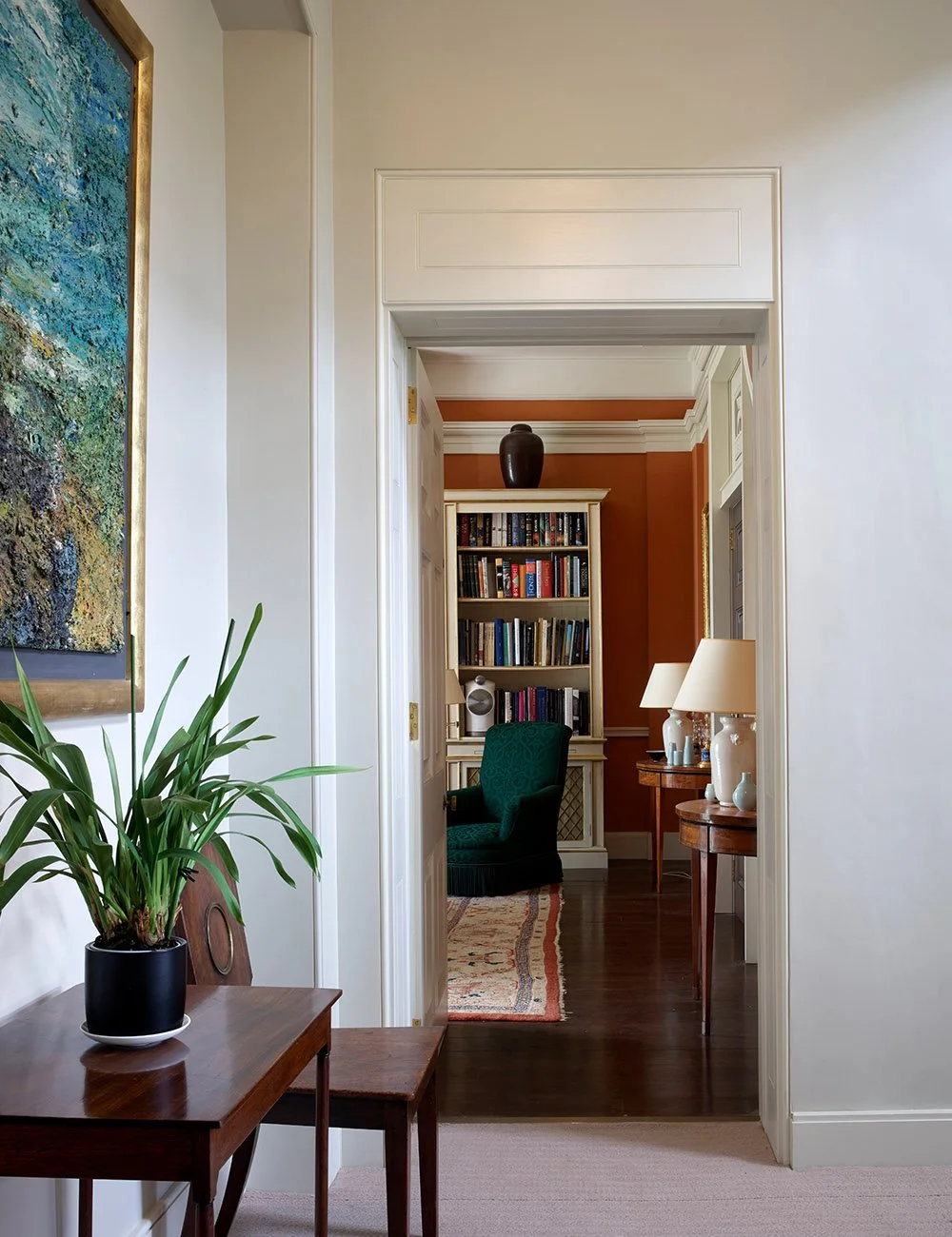 Aligned doorways creating an enfilade through the principal reception rooms of a historic London apartment with restored classical detailing.