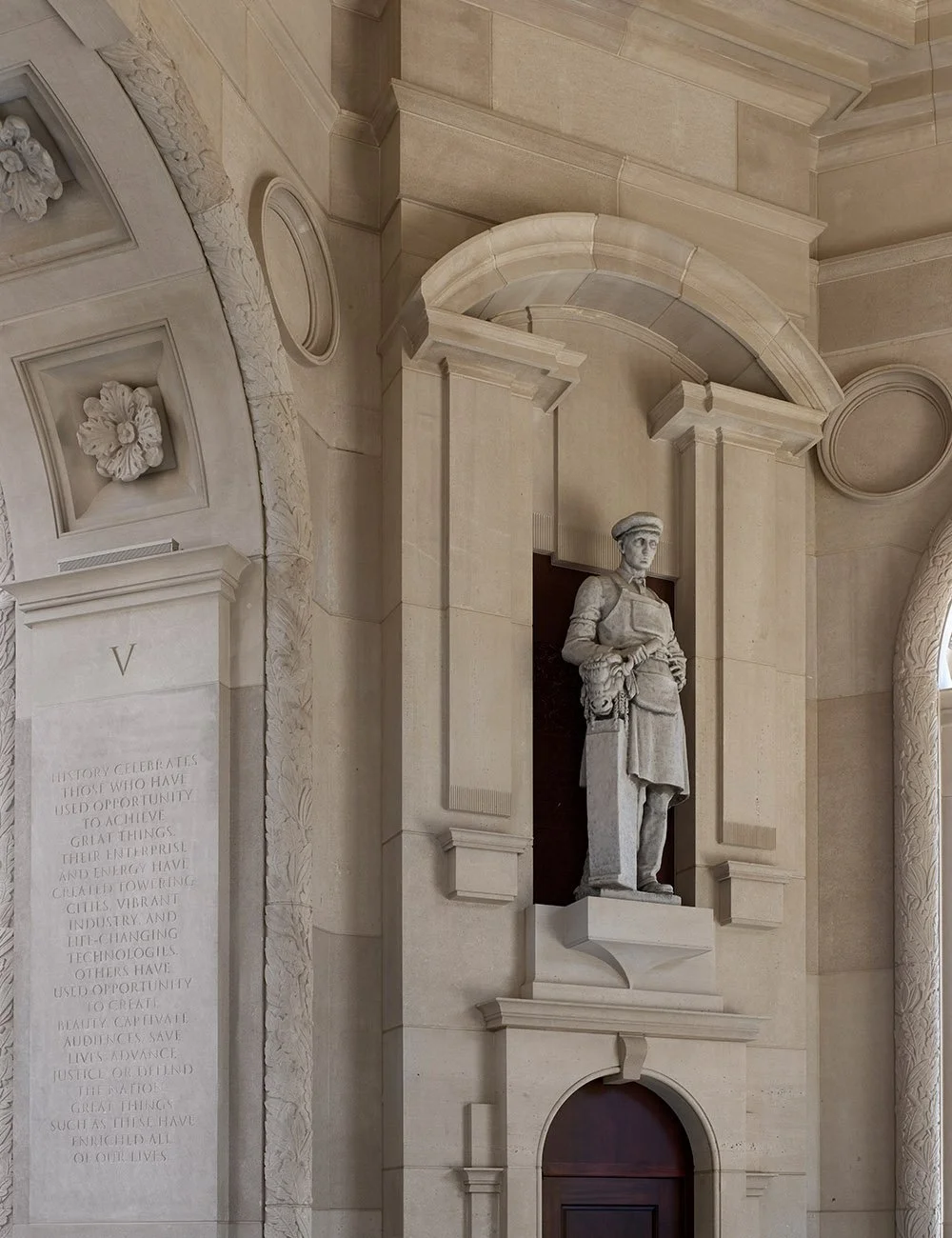 Classical statue set within a carved stone niche featuring traditional architectural detailing at The Campanile.