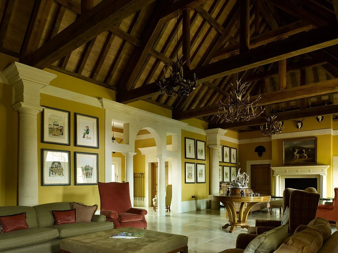 Vaulted great hall of the Shooting Lodge in Gloucestershire with exposed timber roof structure, classical arches and reception seating.