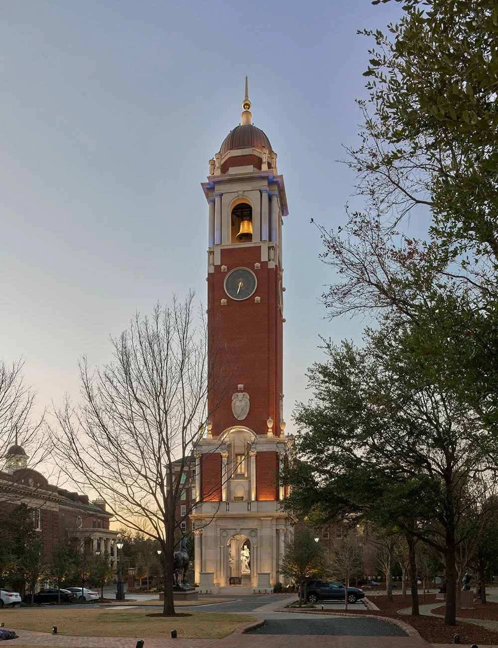 The Campanile clock tower illuminated at dusk within its landscaped setting in Dallas, Texas.