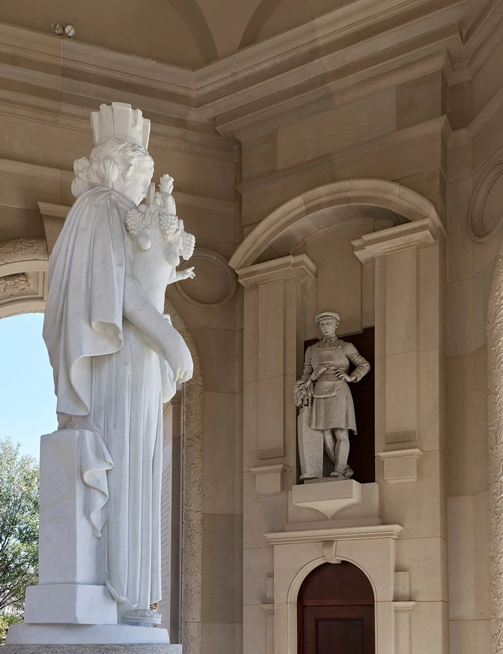 Monumental sculpture framed by classical stone architecture inside The Campanile in Dallas, Texas.