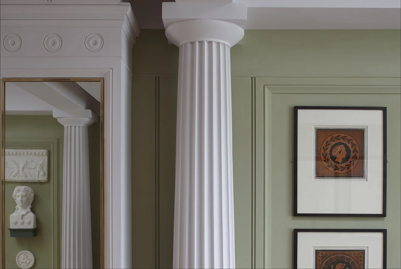 Classical interior detail with fluted column, decorative frieze and sculptural bust at London courtyard house by Craig Hamilton Architects
