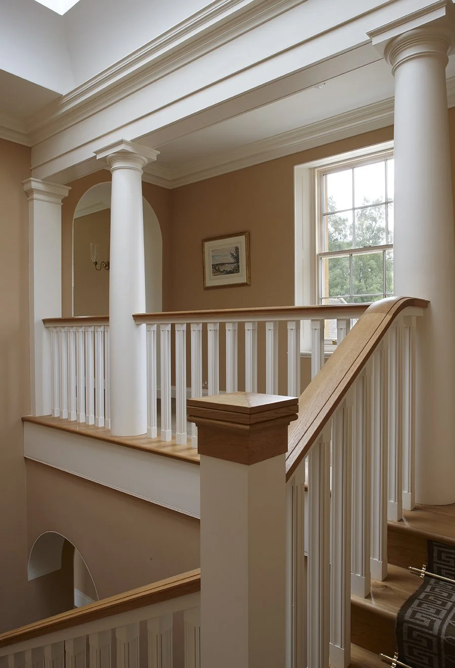 Classical stair landing with columns and natural light by Craig Hamilton Architects