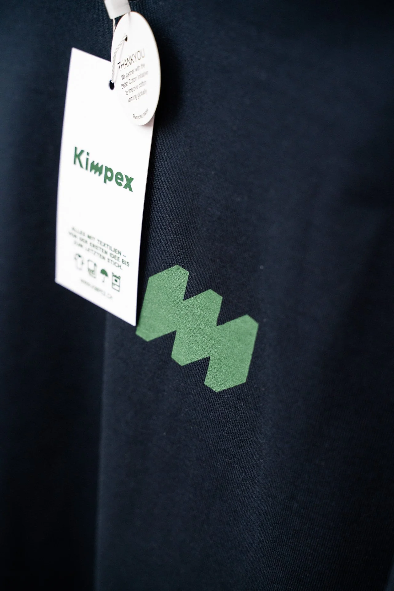 Etikette an einem Pullover mit Kimpex-Logo 
