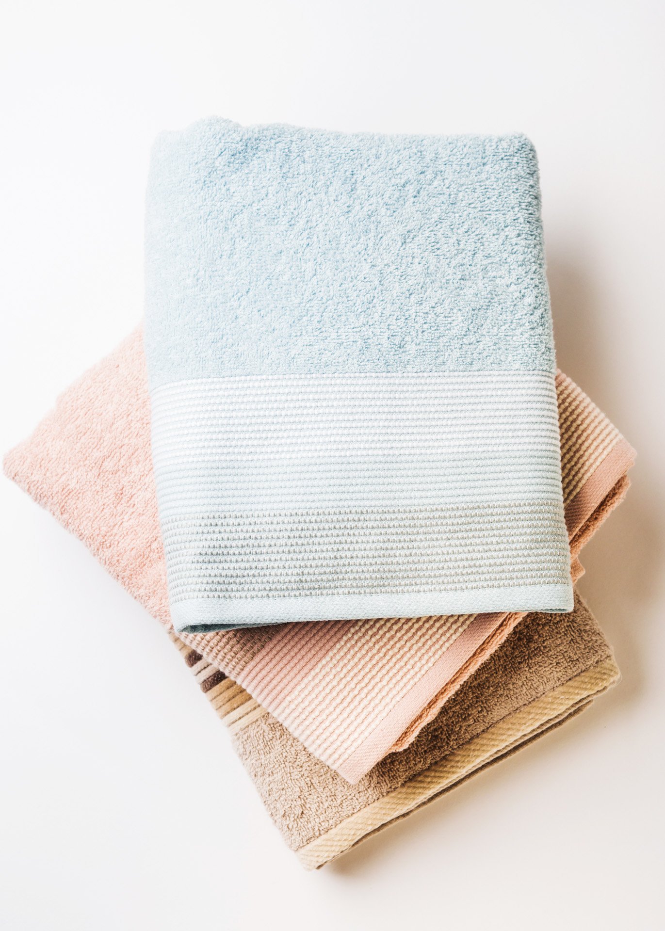 pastel-color-clean-folded-towels-on-white-backgrou-2025-03-24-04-28-29-utc.jpeg