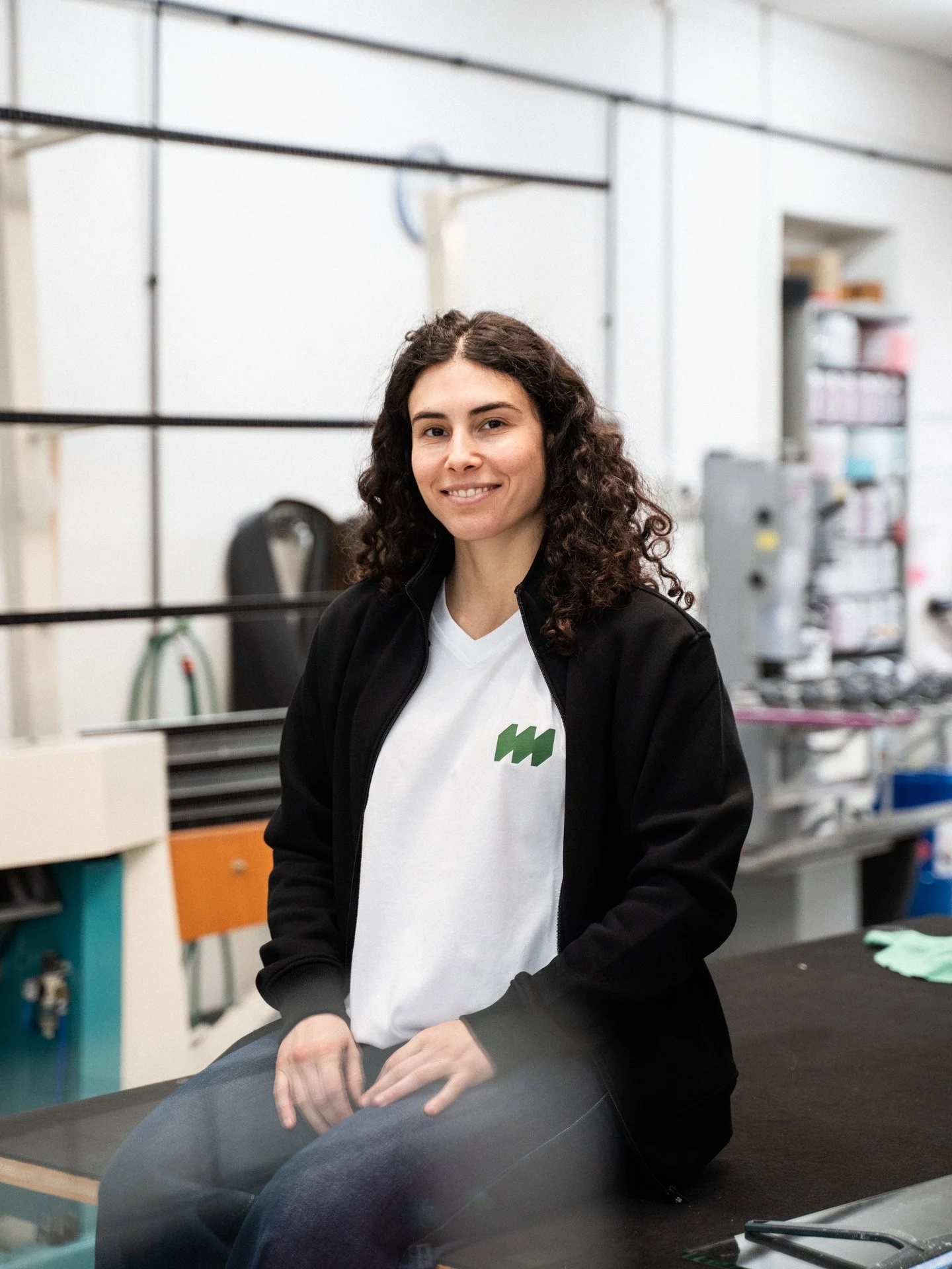 Frau sitzt auf einem Tisch und lächelt