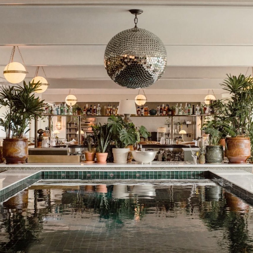 The perfect event venue - Soho House Hong Kong. Chic bar interior with disco ball, indoor plants, and decorative lighting.