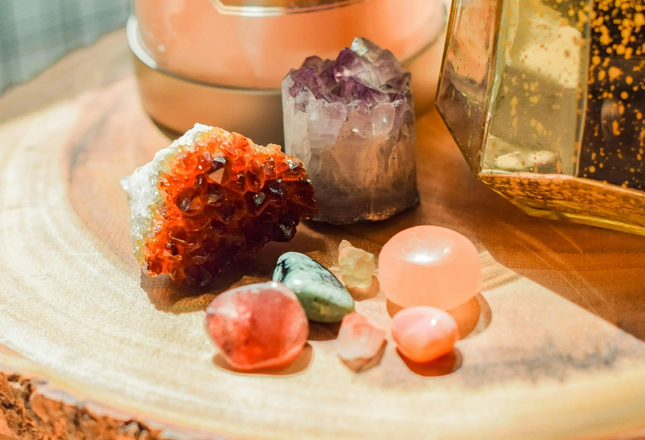Various colorful crystals and gemstones arranged on a wooden surface.
