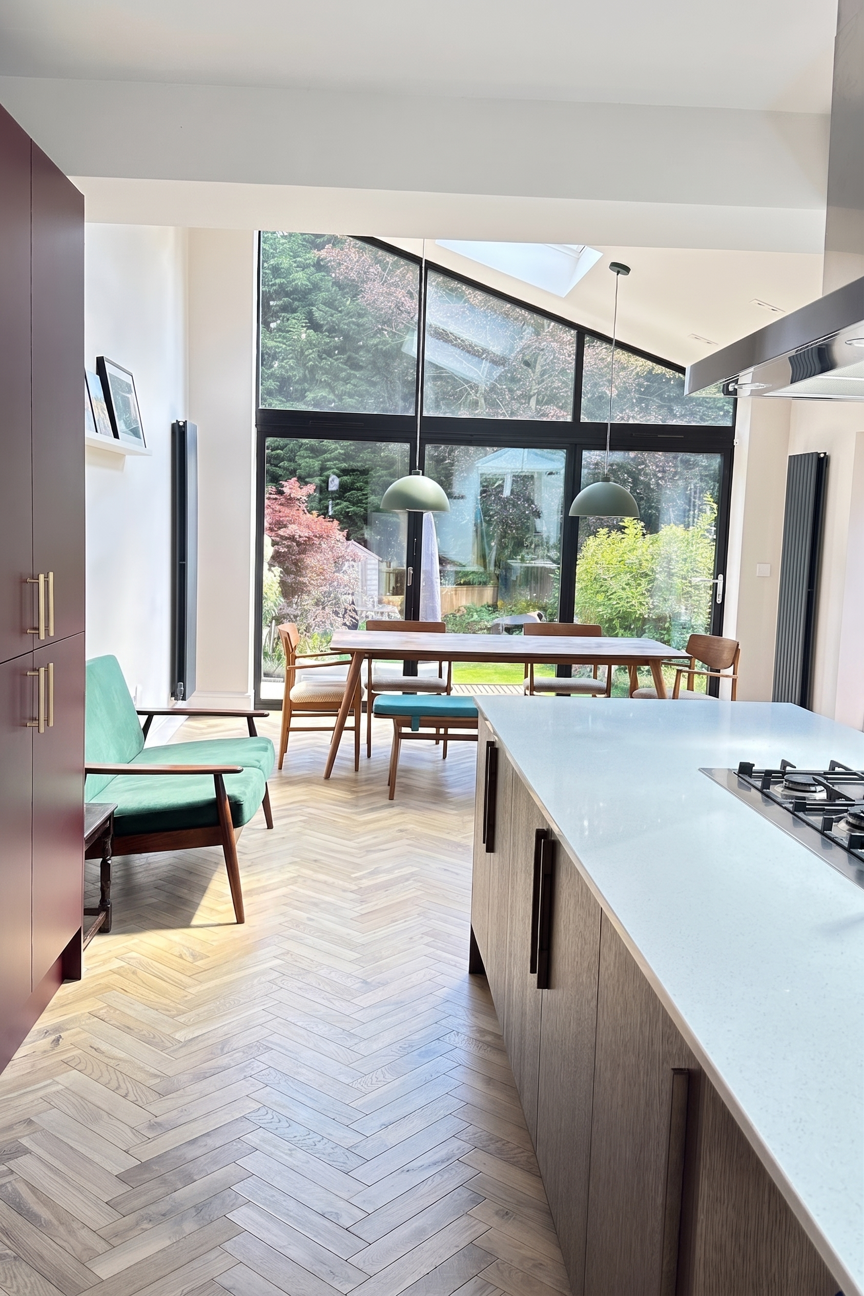 Central kitchen island and dining zone over light herringbone oak flooring in a Birmingham open-plan extension