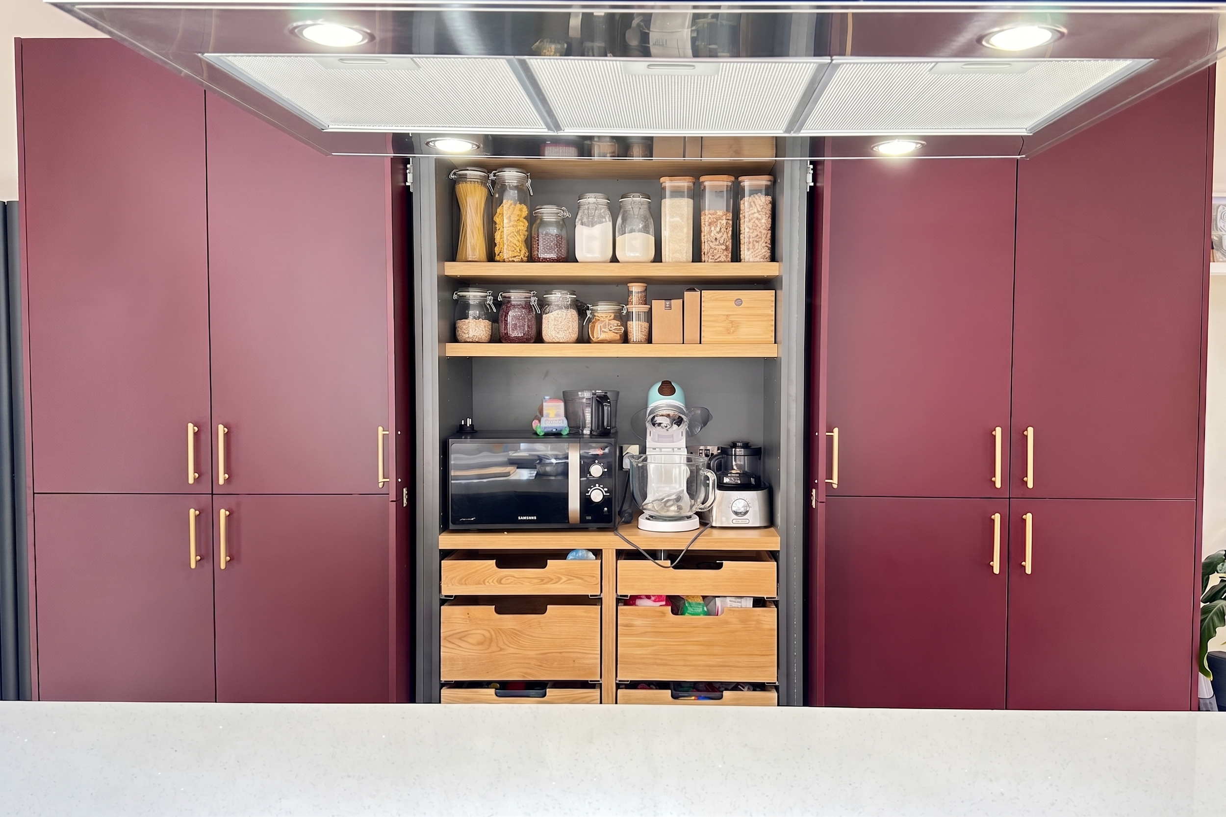 Morello cherry tall larder cabinetry with brushed brass handles in a Birmingham kitchen design