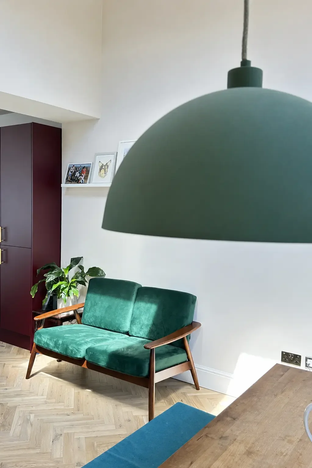 Forest green pendant over the sitting area with morello cherry cabinetry in a Birmingham open-plan kitchen