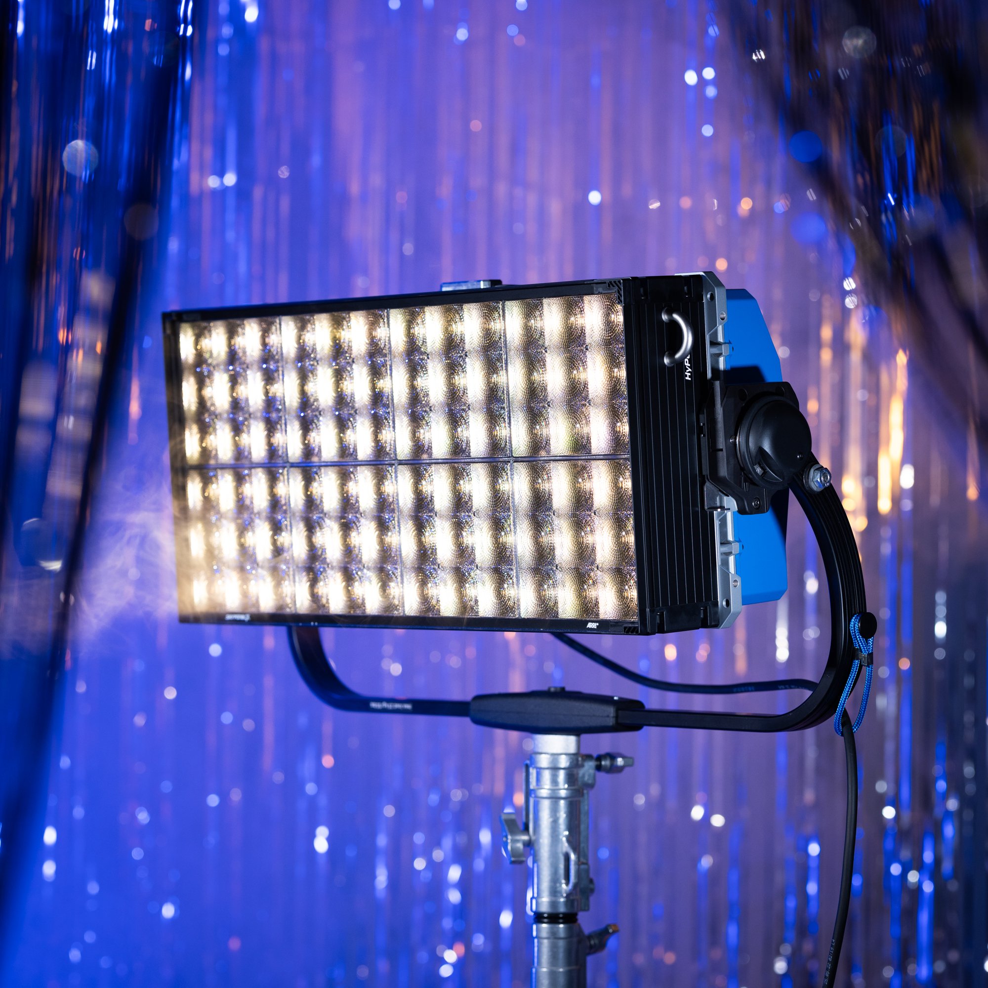An LED studio light mounted on a stand with a purple and blue background.