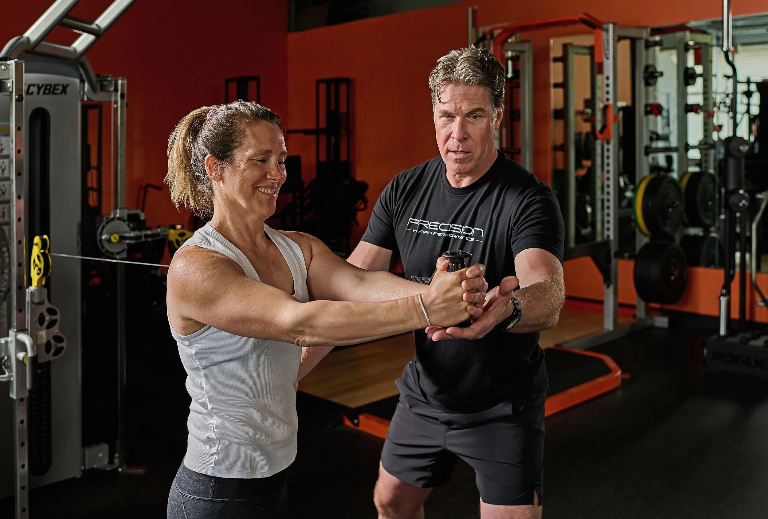 Male Trainer guiding a women through a core exercise