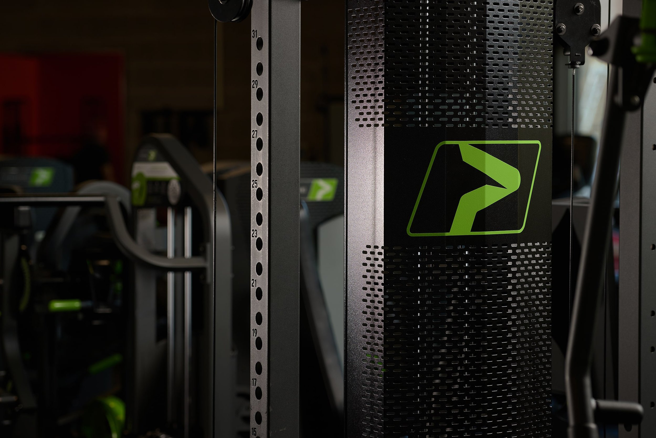 Rows of weightlifting equipment, including standard barbells and weight plates in a gym setting.