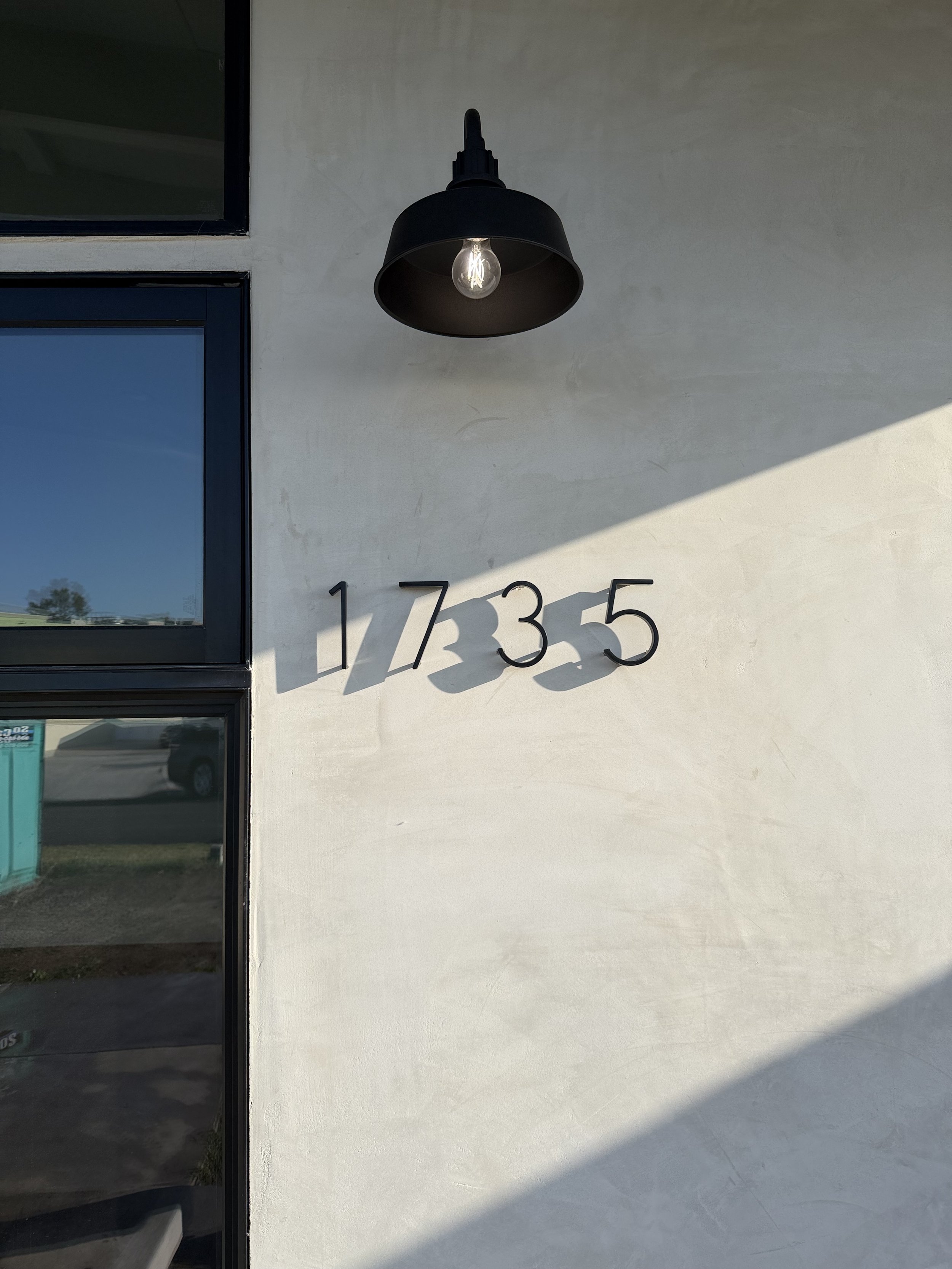 Exterior of building with house number 17335 and a black wall-mounted outdoor light fixture