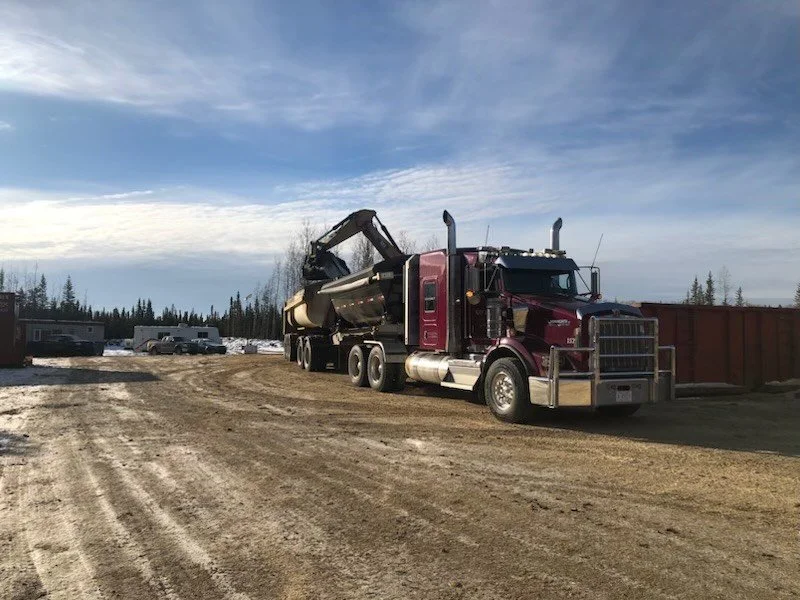 Drill cuttings being loaded onto a compliant truck at an oil rig site