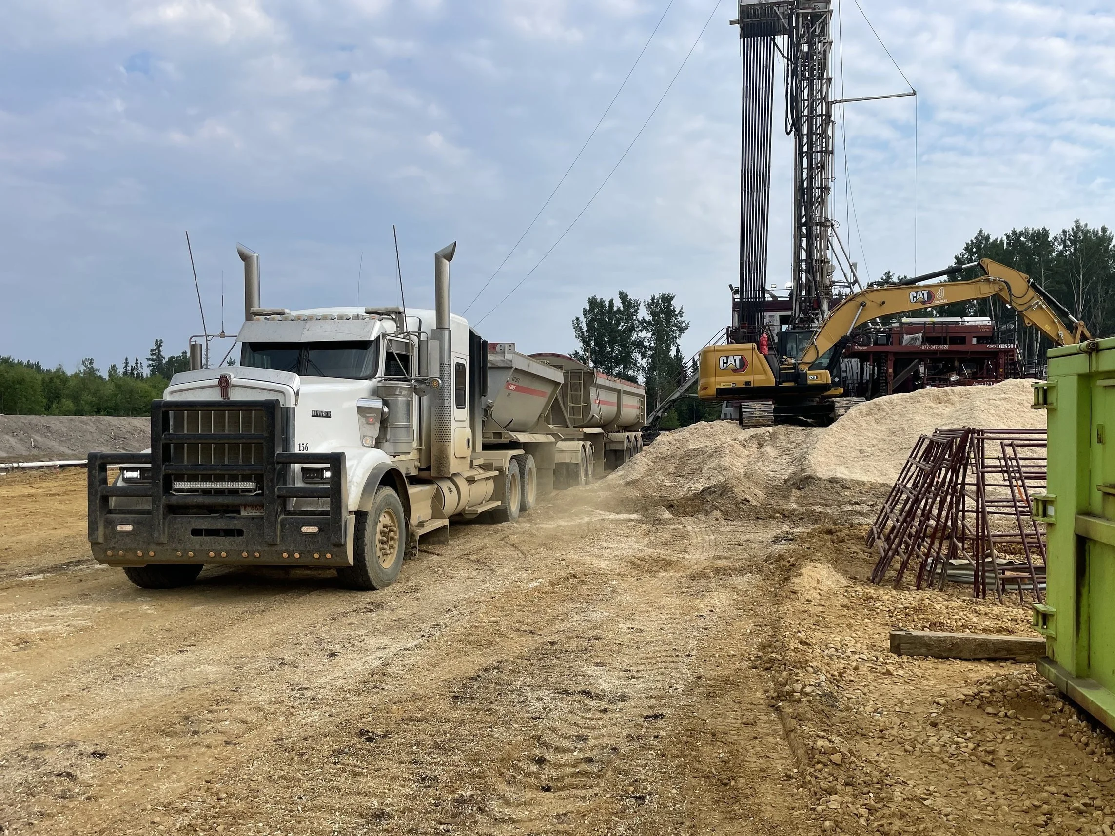 Tridem End Dump Truck from Willowhill Holdings Inc in action on an oilfield transport route.