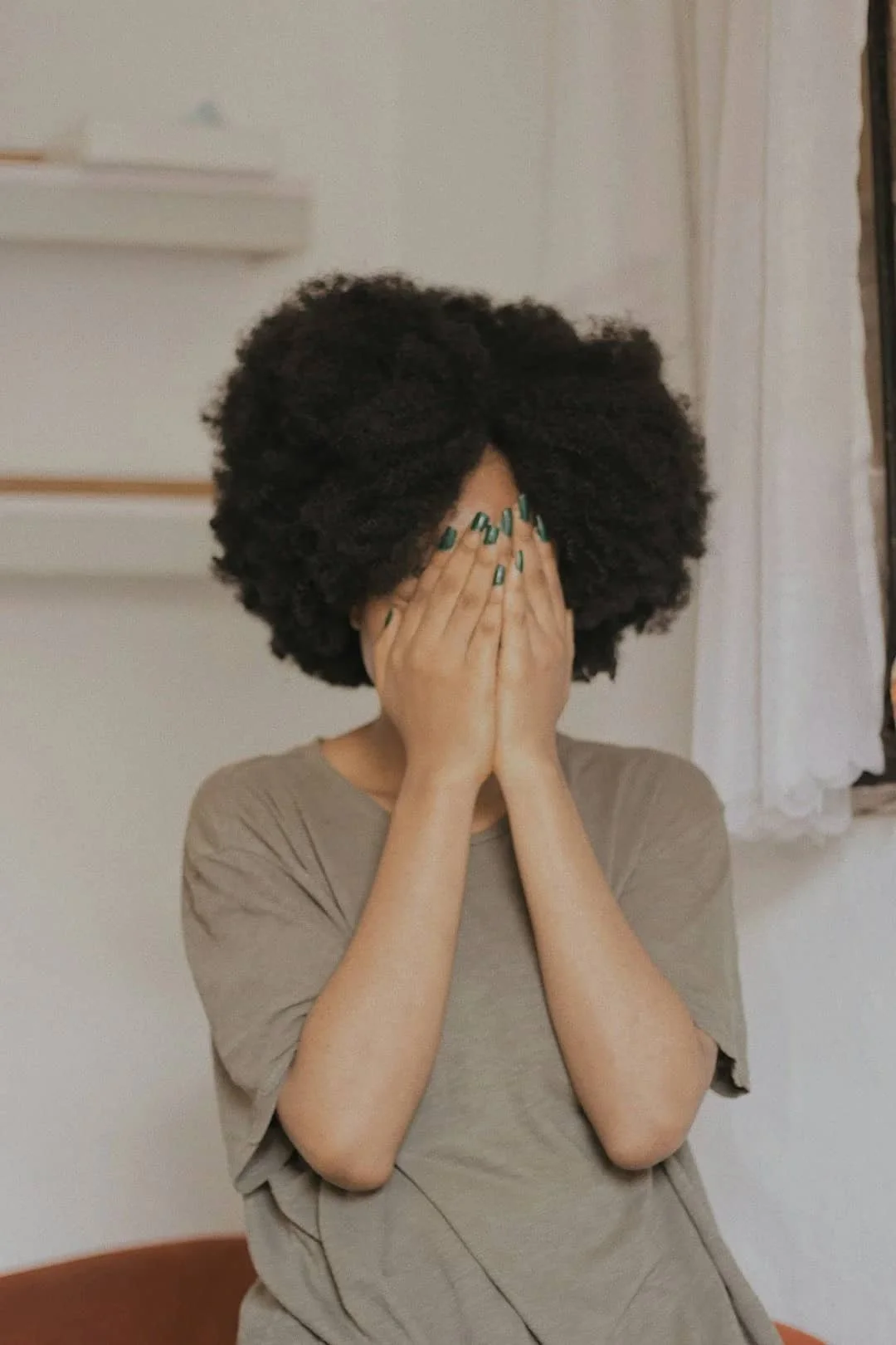 Person covering their face with their hands, representing emotional overwhelm and the fear of feeling difficult emotions.