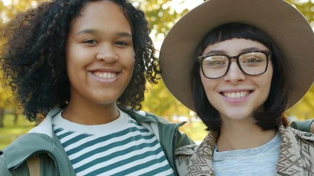 Two people smiling together outdoors, reflecting connection and support during nervous system healing.