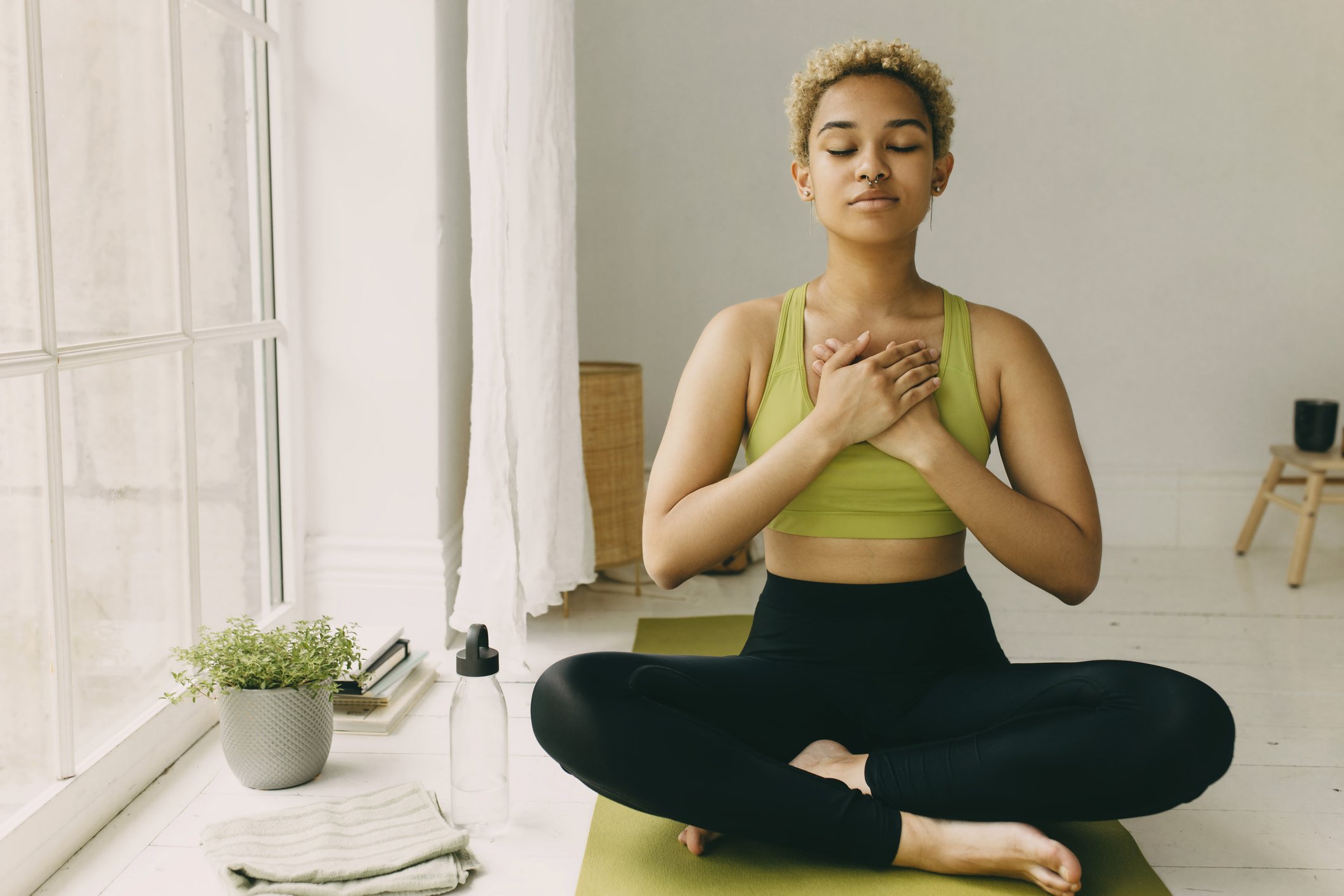 woman sitting cross-legged in somatic meditation with eyes closed