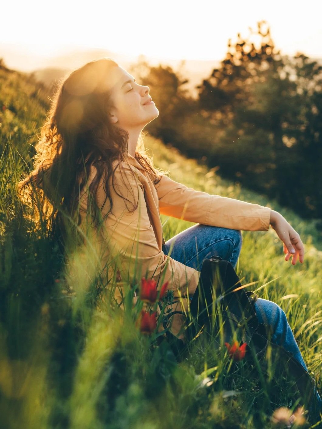 Woman sitting peacefully outdoors in the afternoon sun.