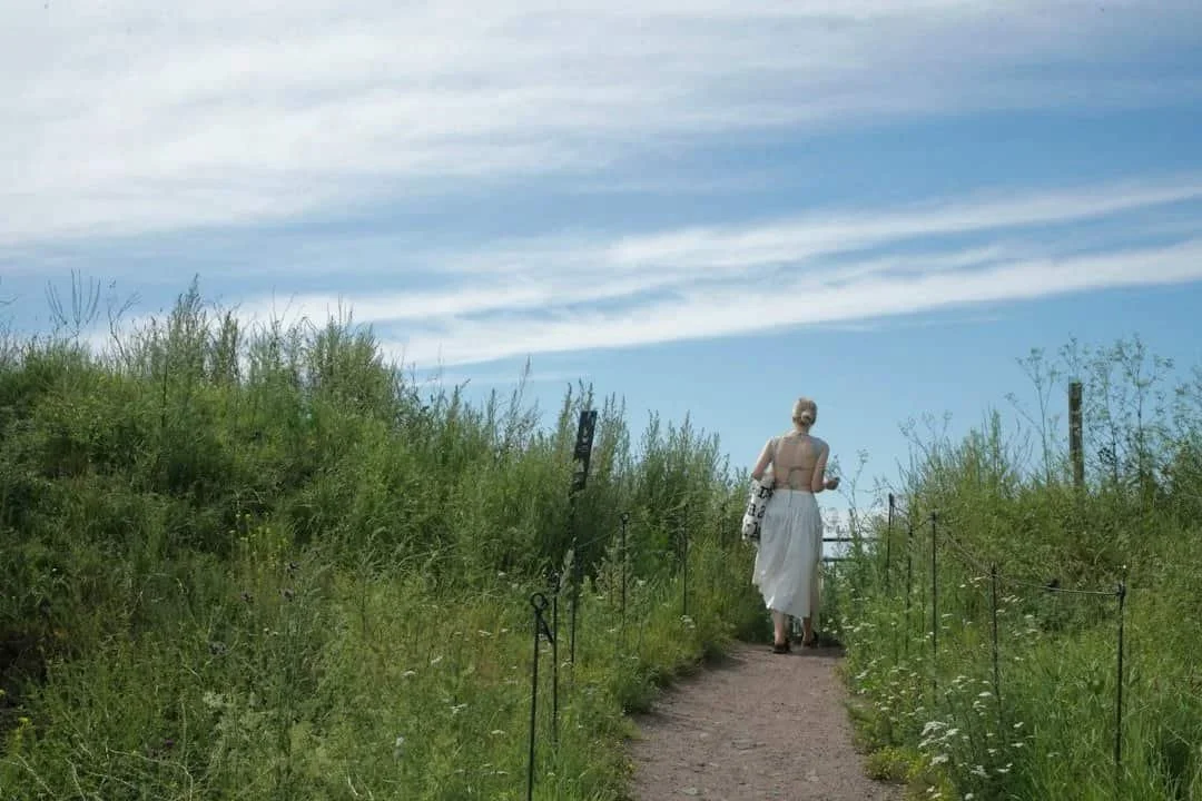 Person walking along a quiet nature path, representing moving beyond people-pleasing toward greater choice and self-trust.