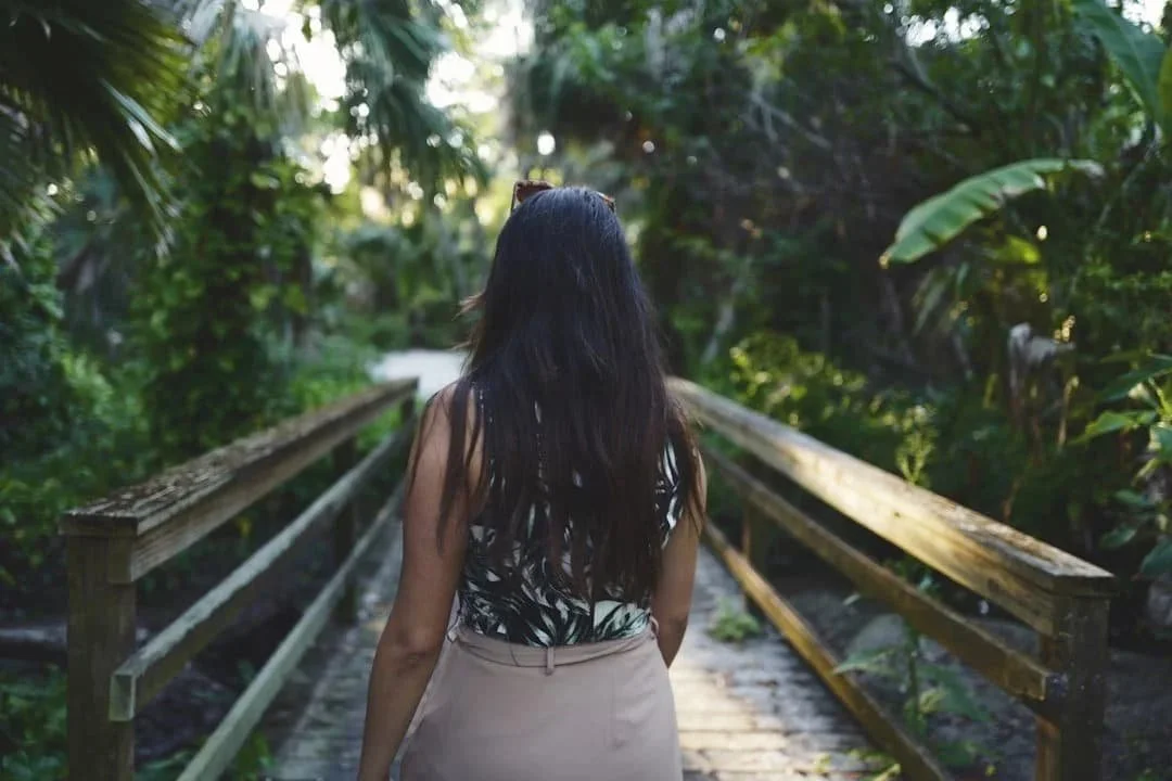 Woman walking along a quiet path surrounded by trees