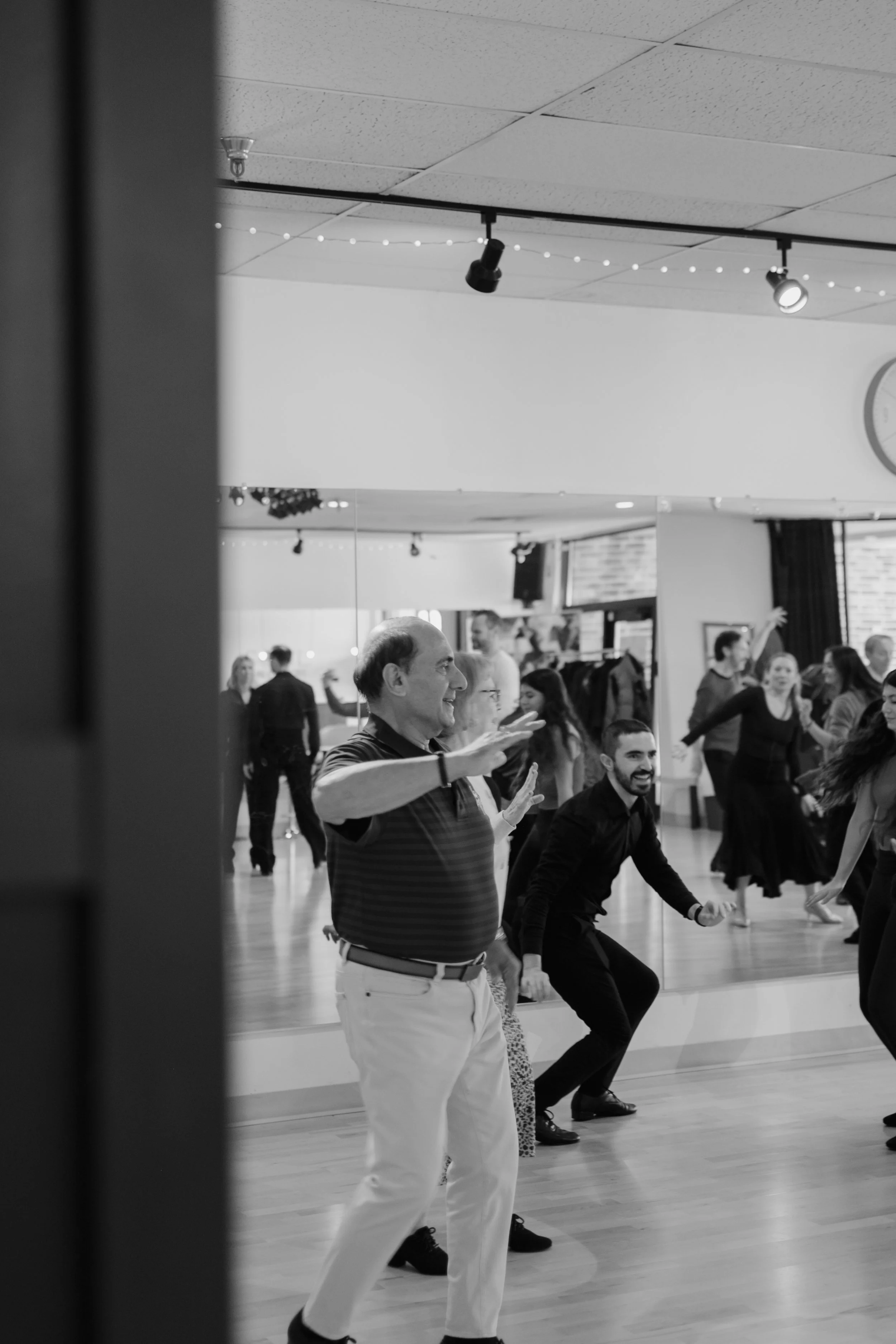 People dancing and having fun at a social event or dance class in a hall.