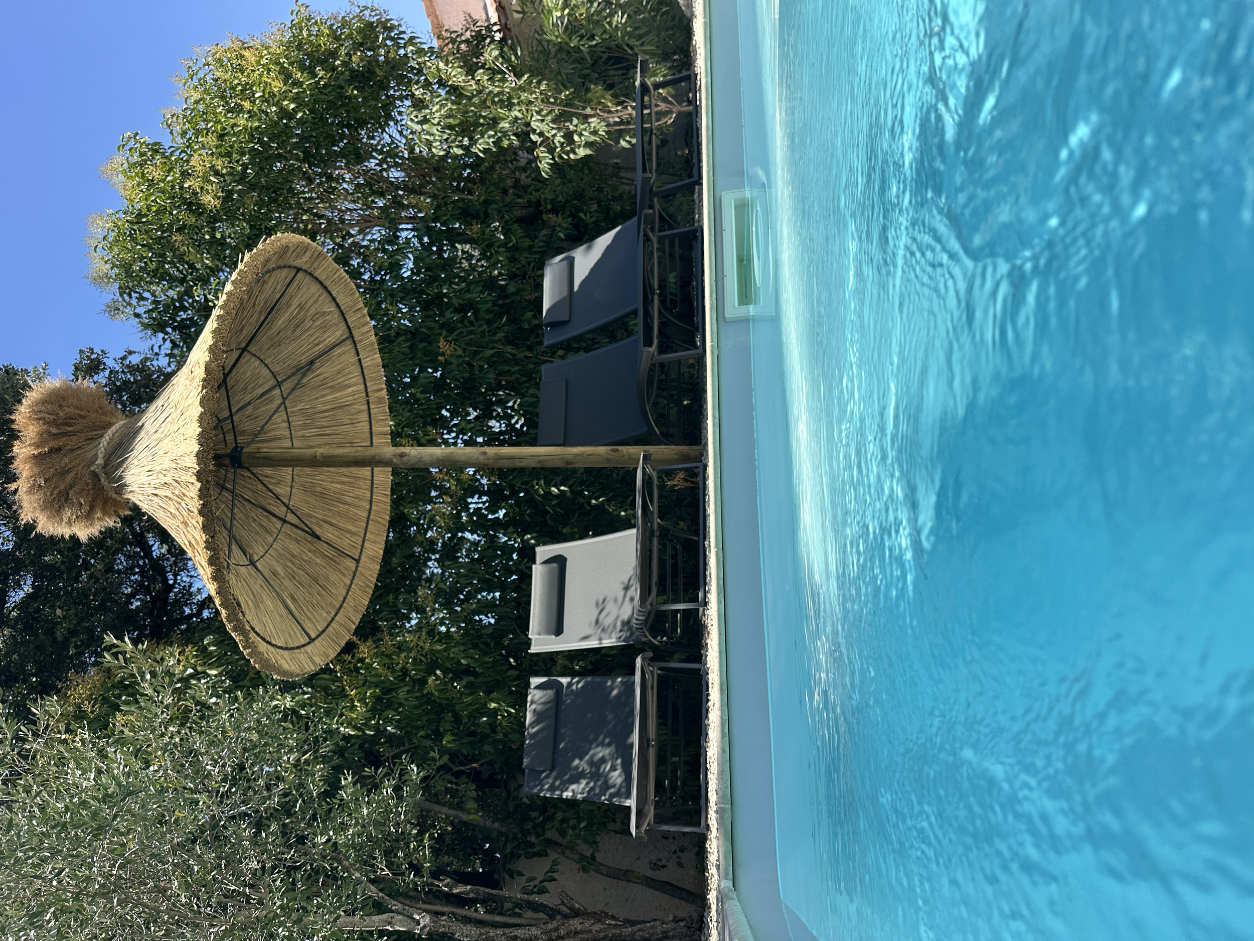 L’ombre douce d’un parasol camarguais au bord de l’eau.