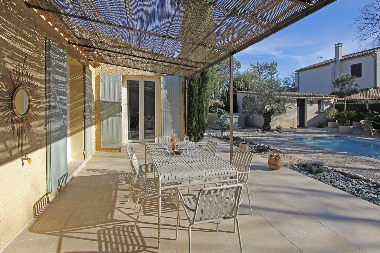 Vue sur la terrasse ou la table est dressée avec une bouteille de rosé, vue sur les oliviers et le spa