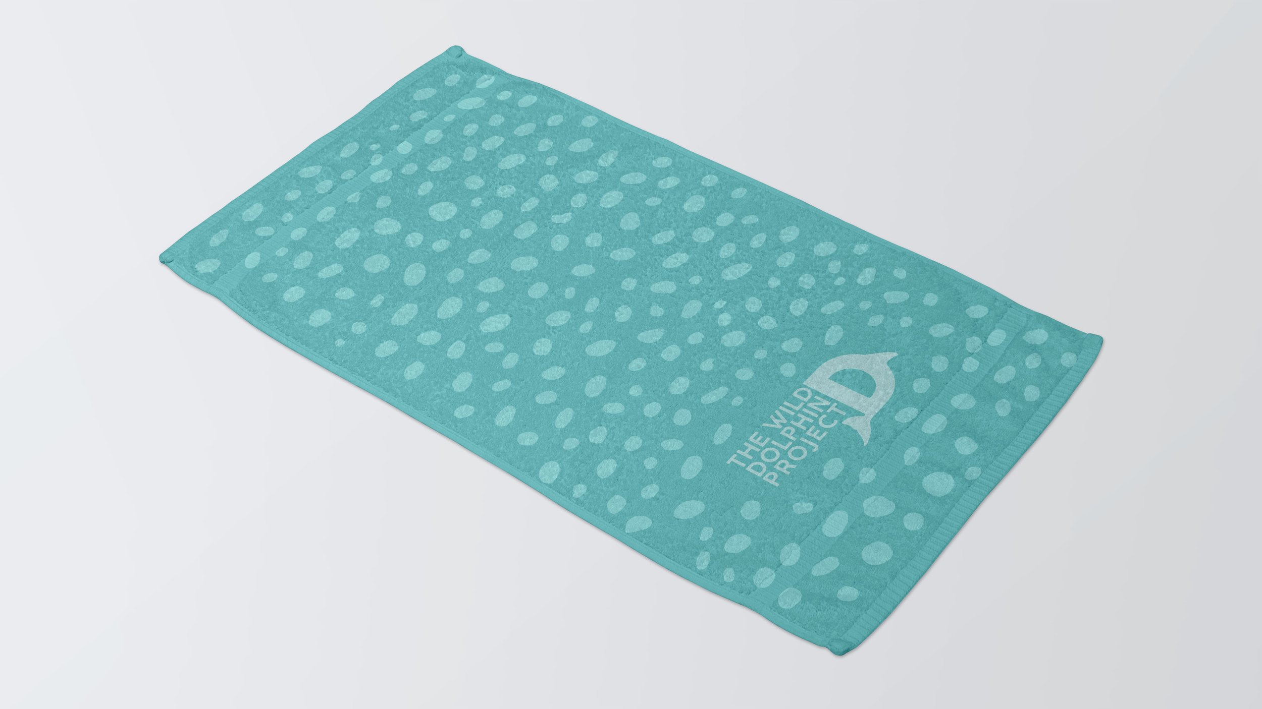 Turquoise towel with white polka dots and "The Wild Dolphin Project" text.