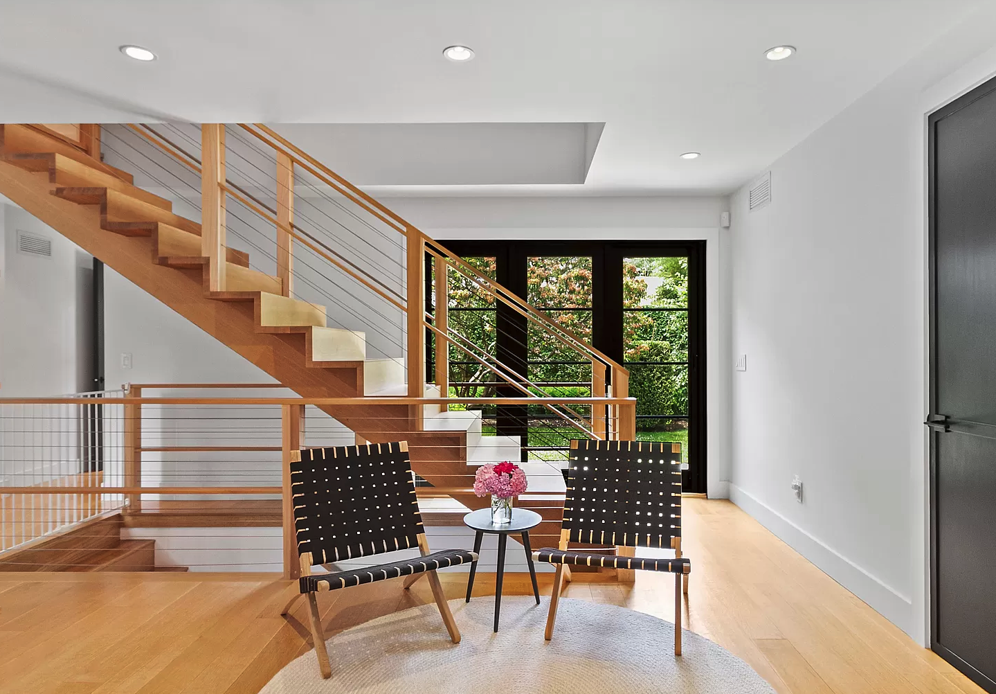 modern-wood-staircase-entryway-black-chairs-natural-light.png