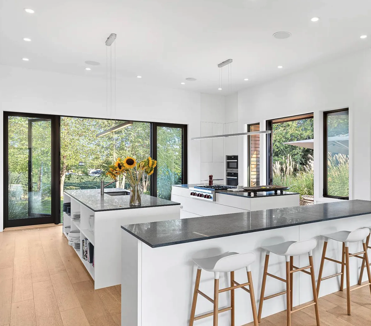modern-open-kitchen-dual-islands-black-countertops-sunlight-view.png