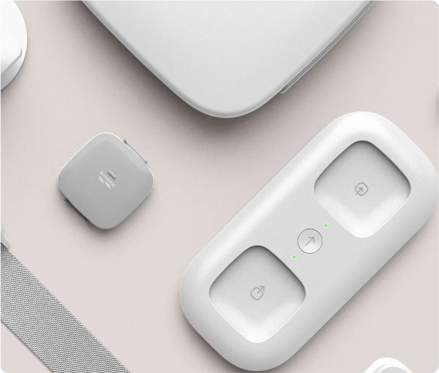 Overhead view of Apple AirTag attached to a key ring, along with other Apple accessories on a light-colored surface.
