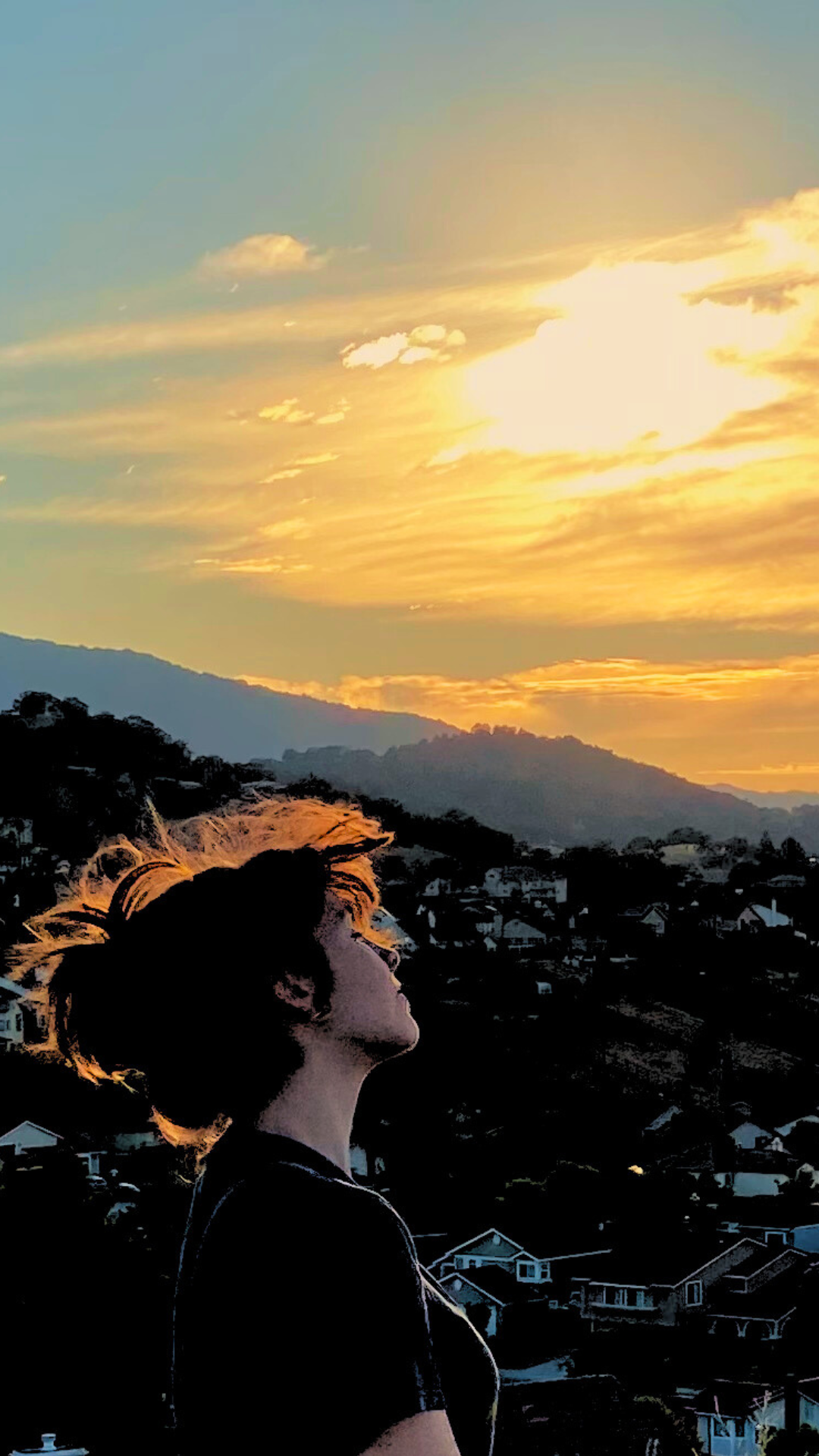 christian girl with sunset behind her and the hills