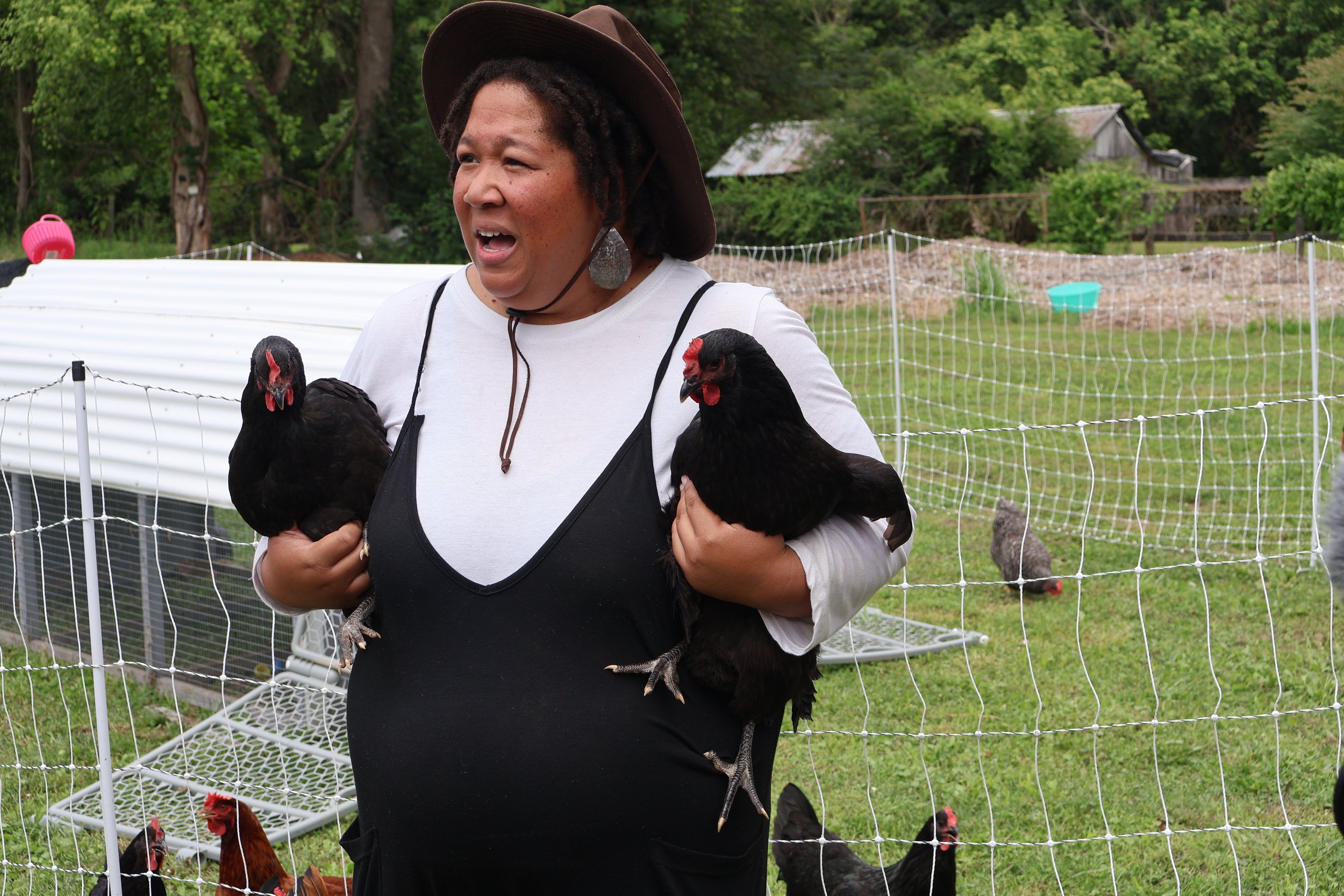  Solidarity Riders learn the art of chicken farming from LeTica, the founder of BearFruit and Grow. 