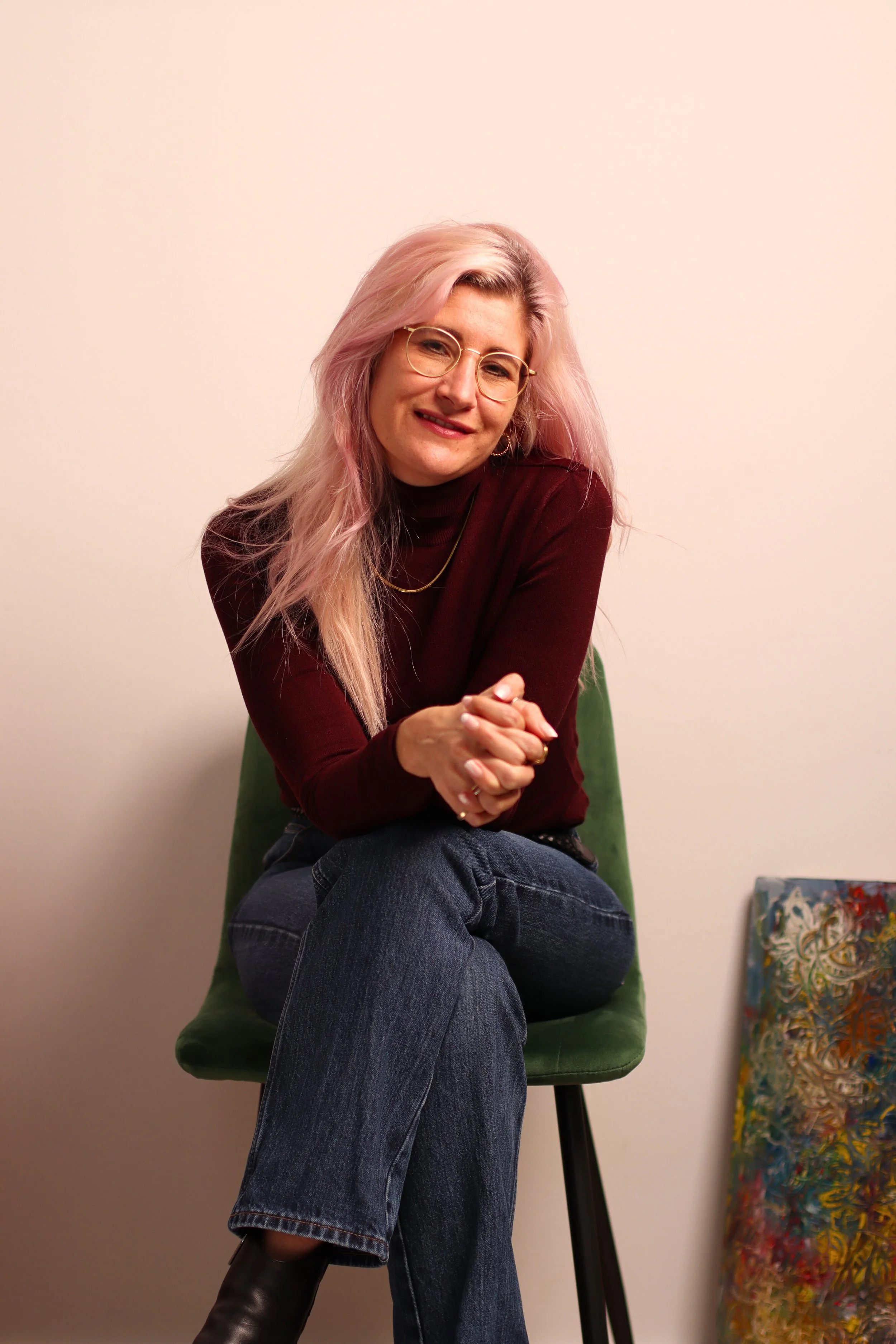 Zoe Coetzee, expressive arts facilitator at the sozo space, sitting on chair smiling