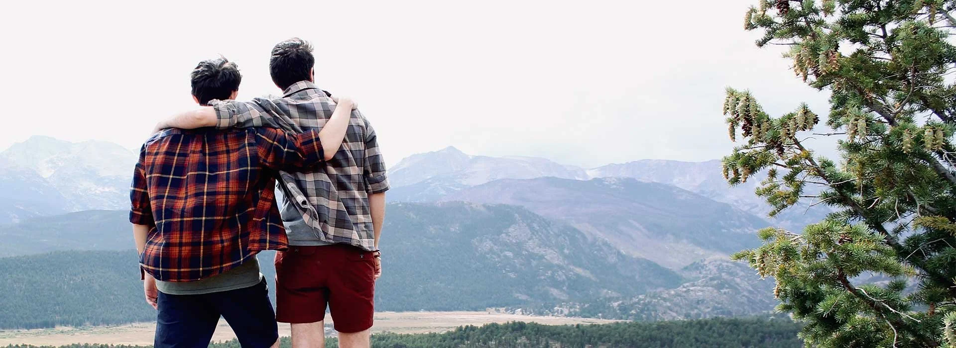 Men arm in arm, looking out over a mountain